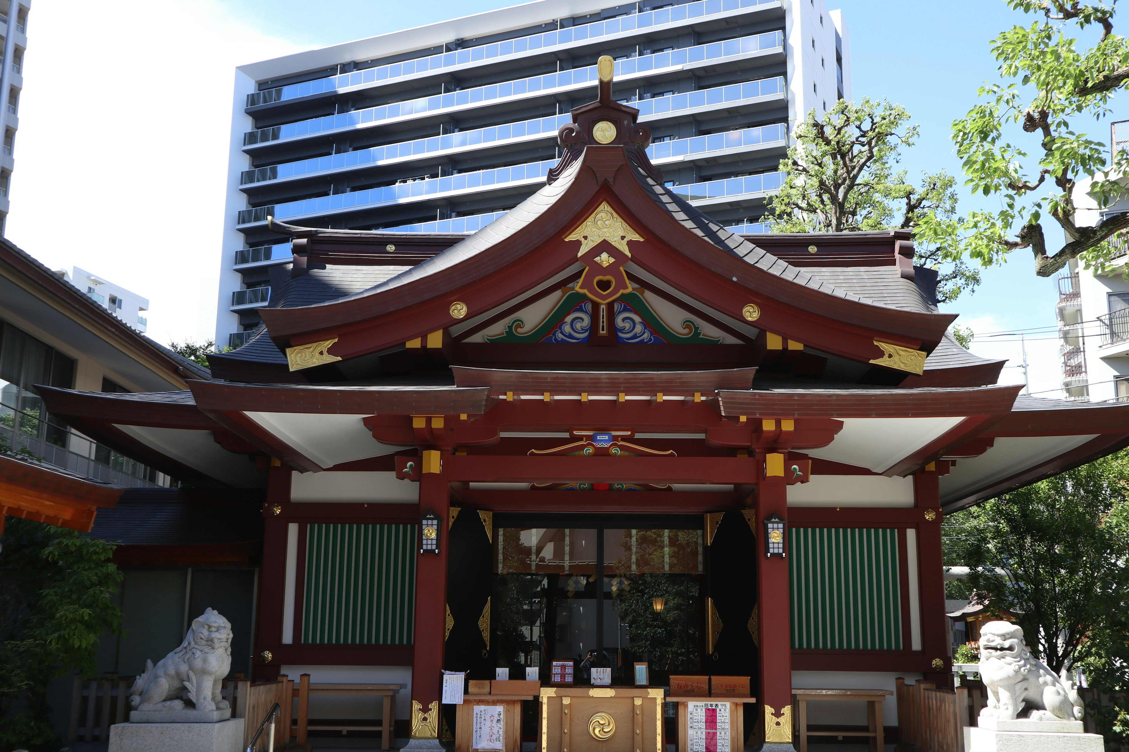 位於現代建築附近的傳統神社，擁有華麗裝飾的屋頂和柱子