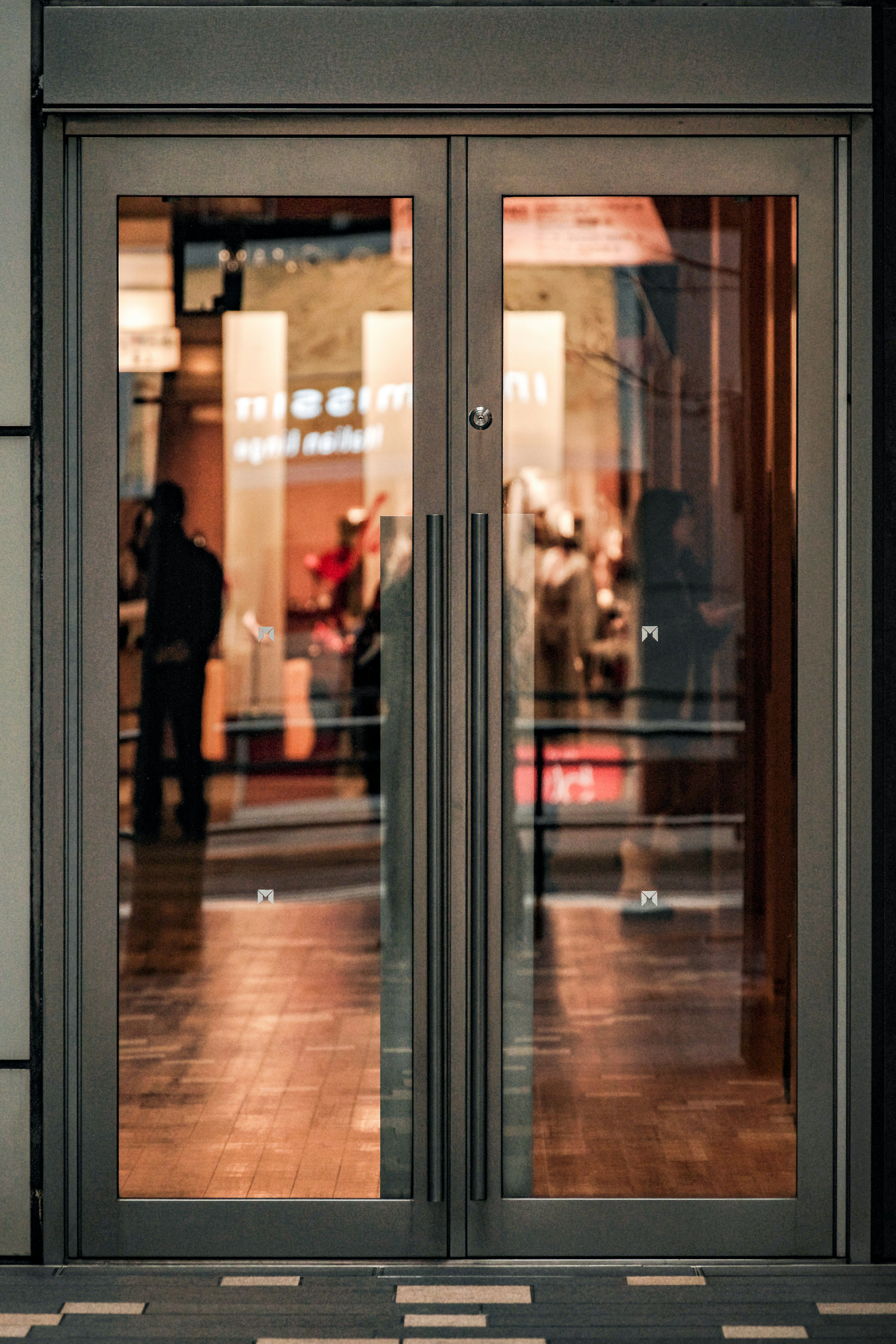 Reflective automatic doors with silhouettes of people