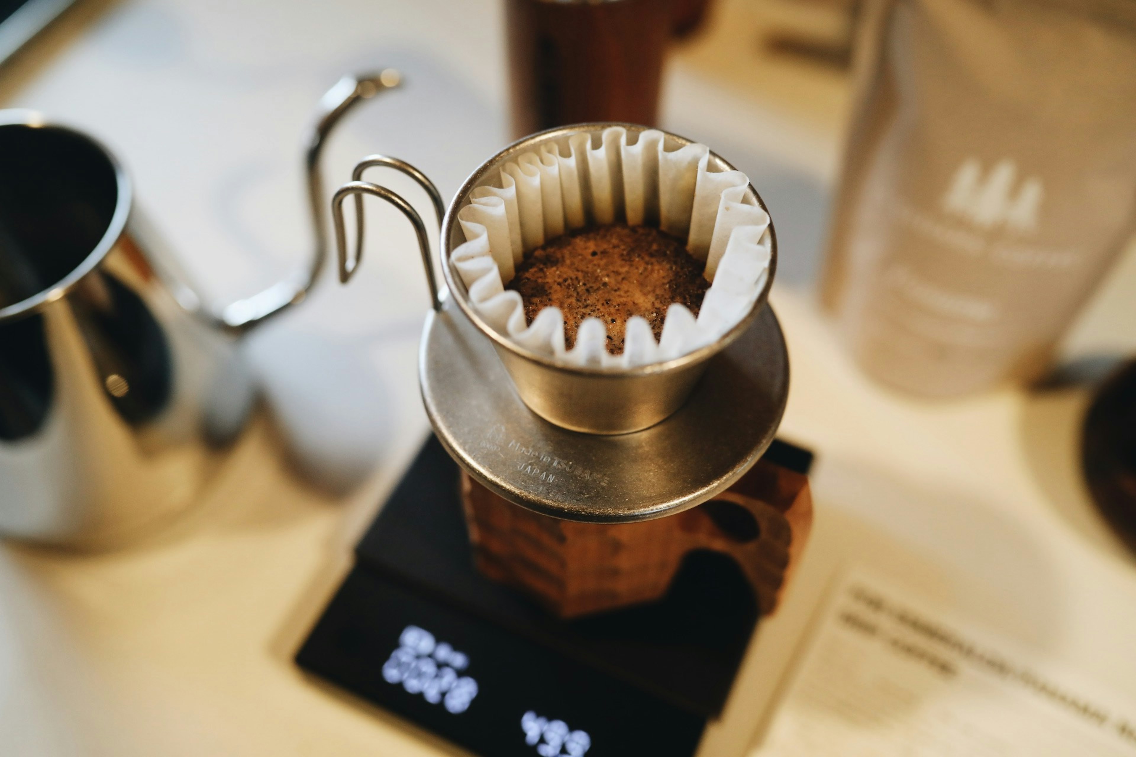 Coffee dripper and scale on a table with brewing equipment