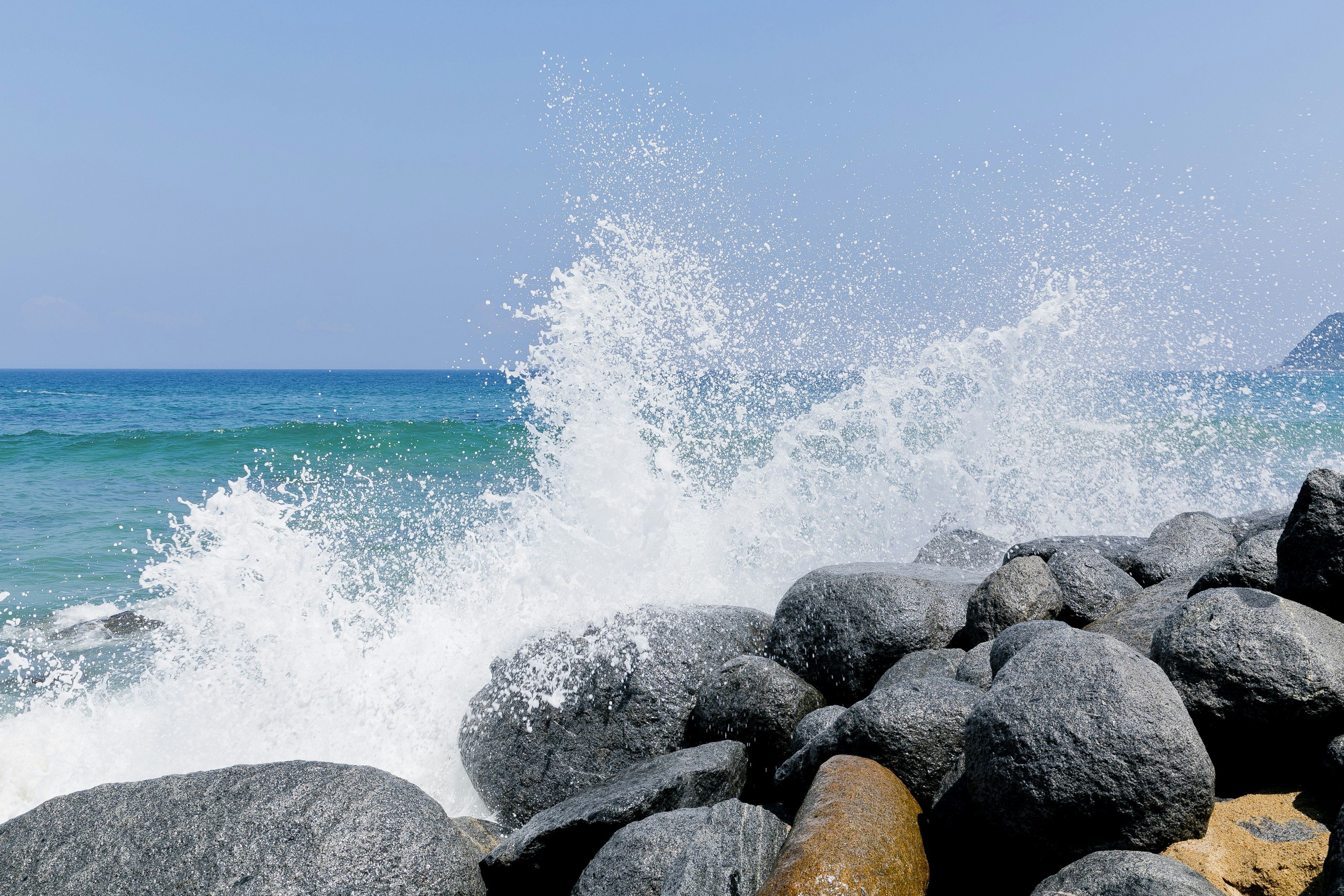 Blue ocean waves crashing against rocks