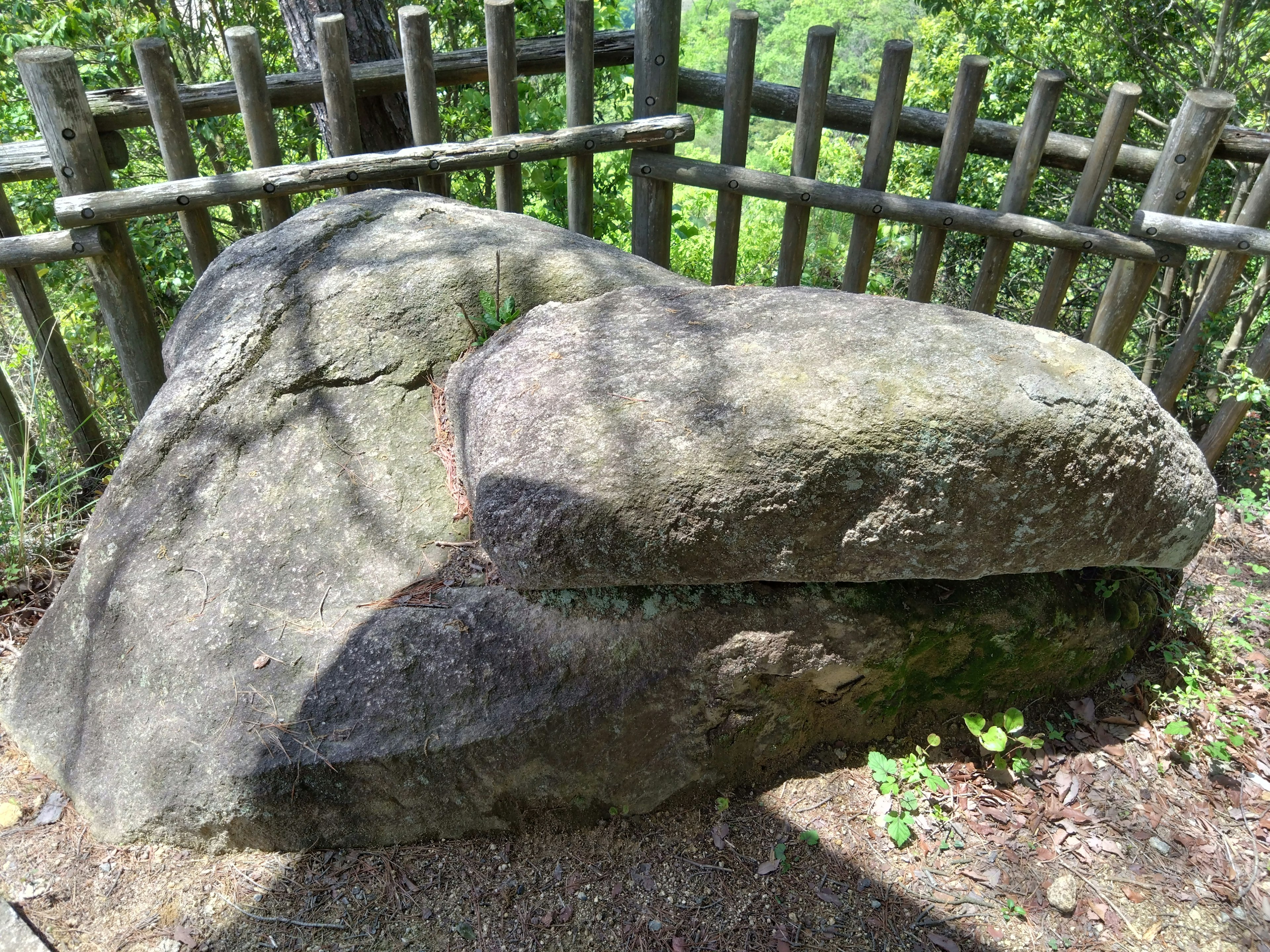 Large rock with a wooden fence in a natural setting