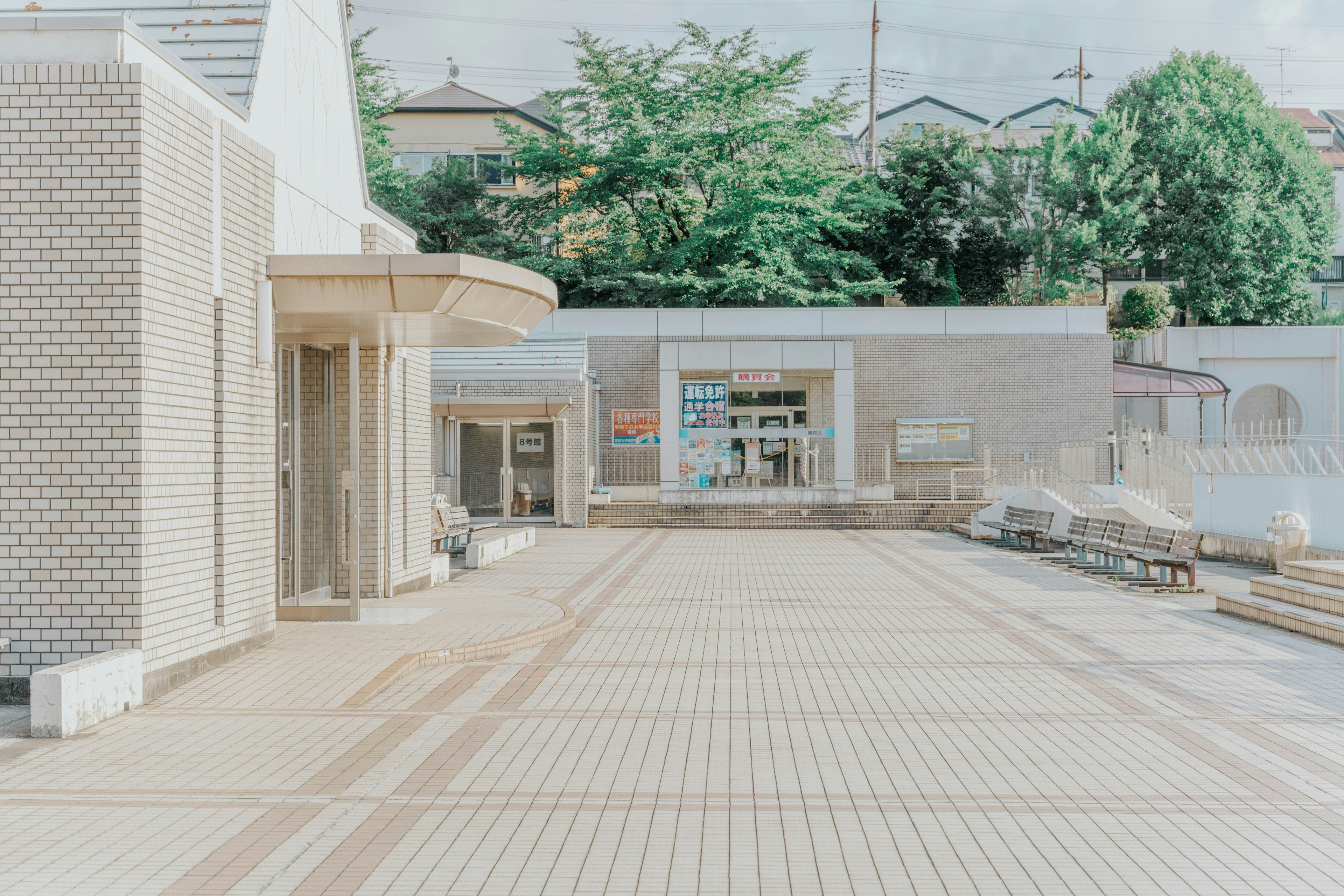 Modernes Gebäude auf einem ruhigen Stadtplatz mit grünen Bäumen