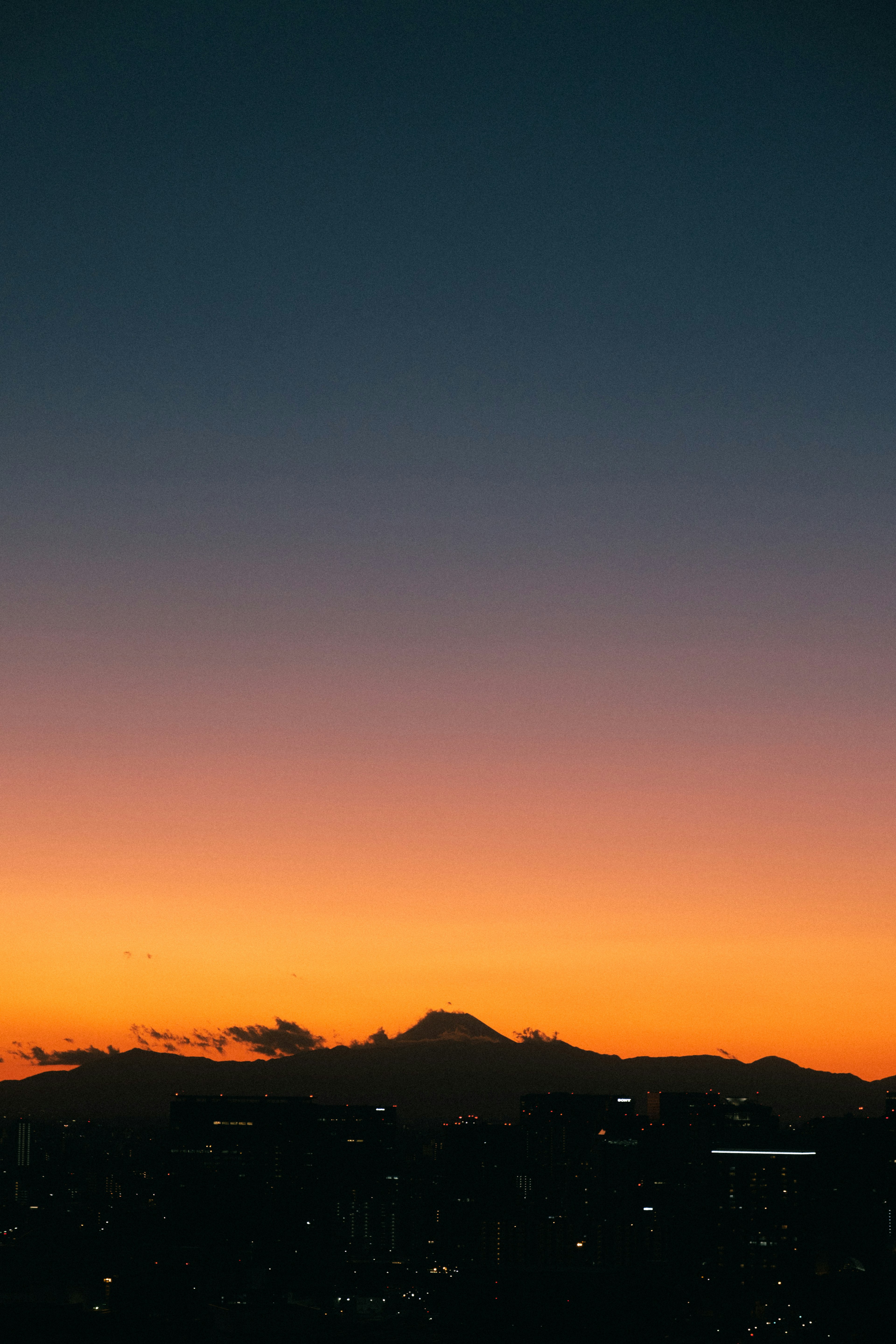 夕焼けの空と富士山のシルエットが見える風景