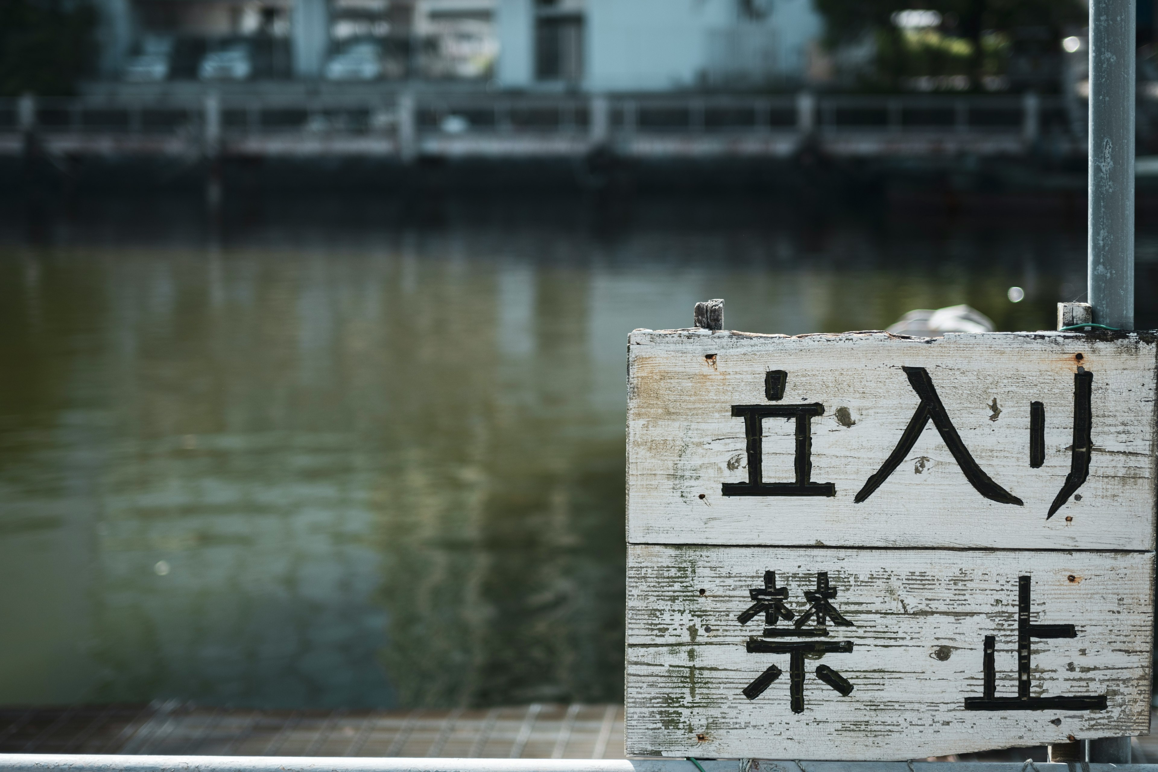 A sign prohibiting entry stands by the water's edge