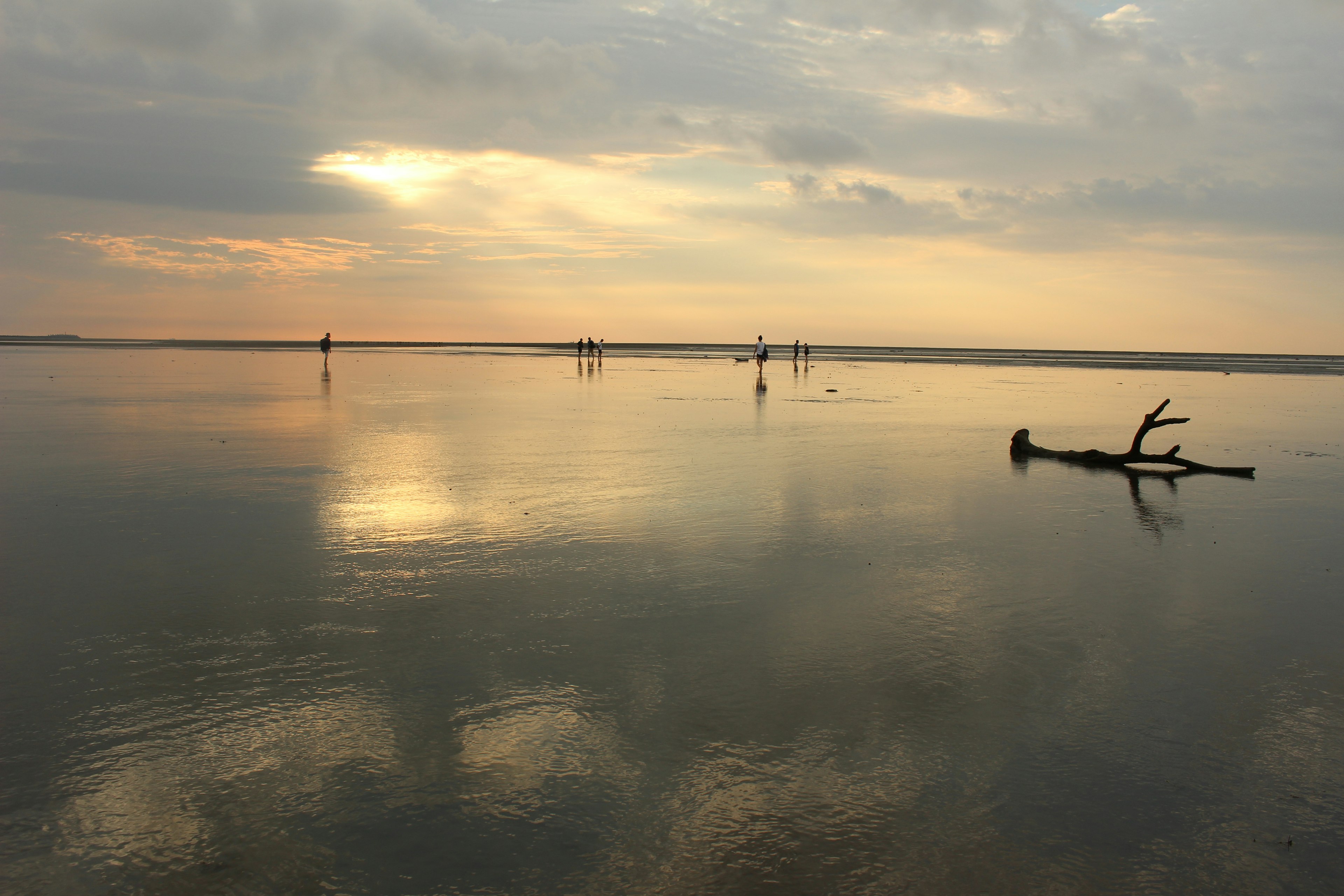 Agua calma reflejando el atardecer y las nubes