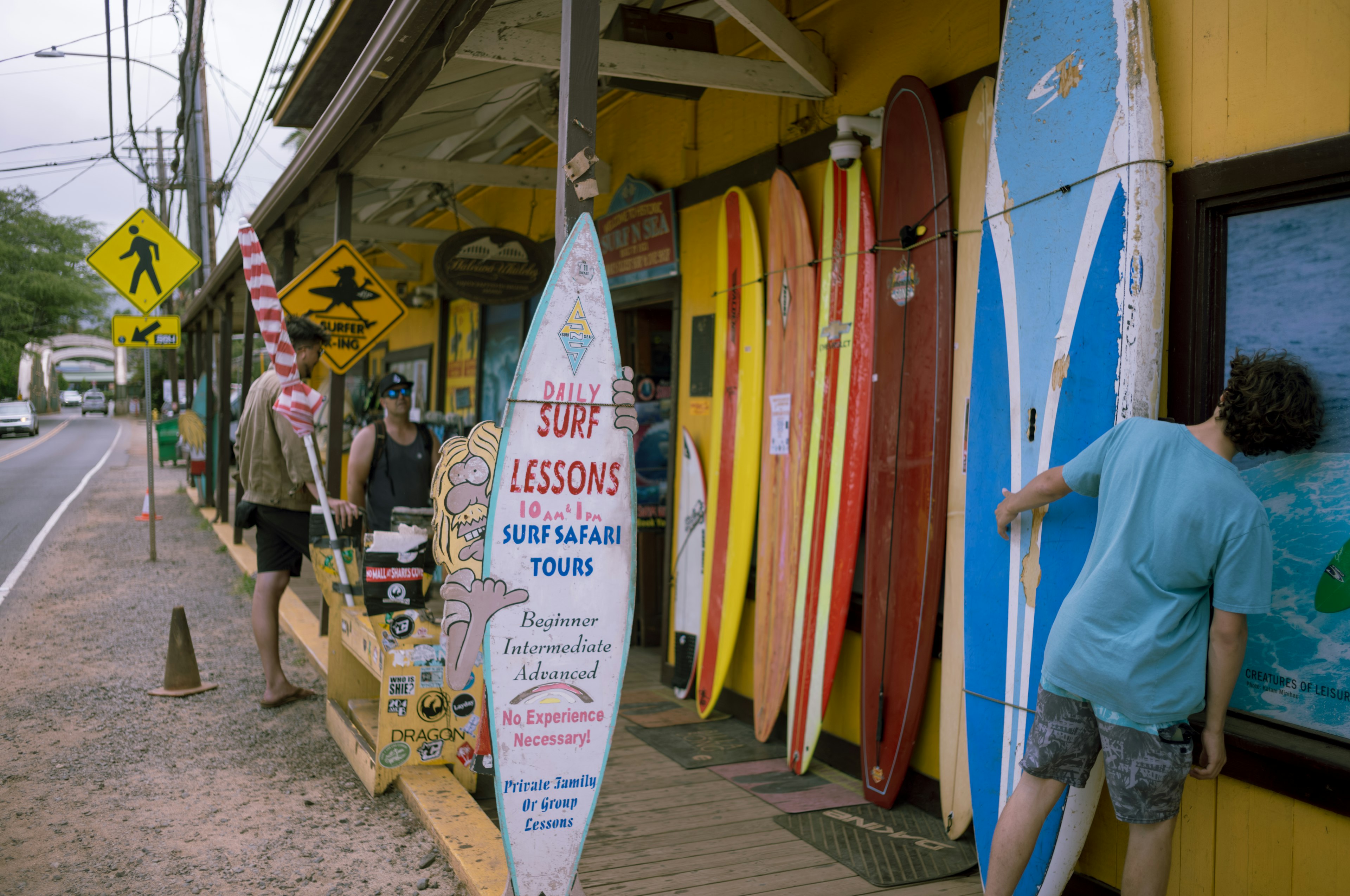 Extérieur d'un magasin de surf avec des planches colorées et un panneau de leçon de surf