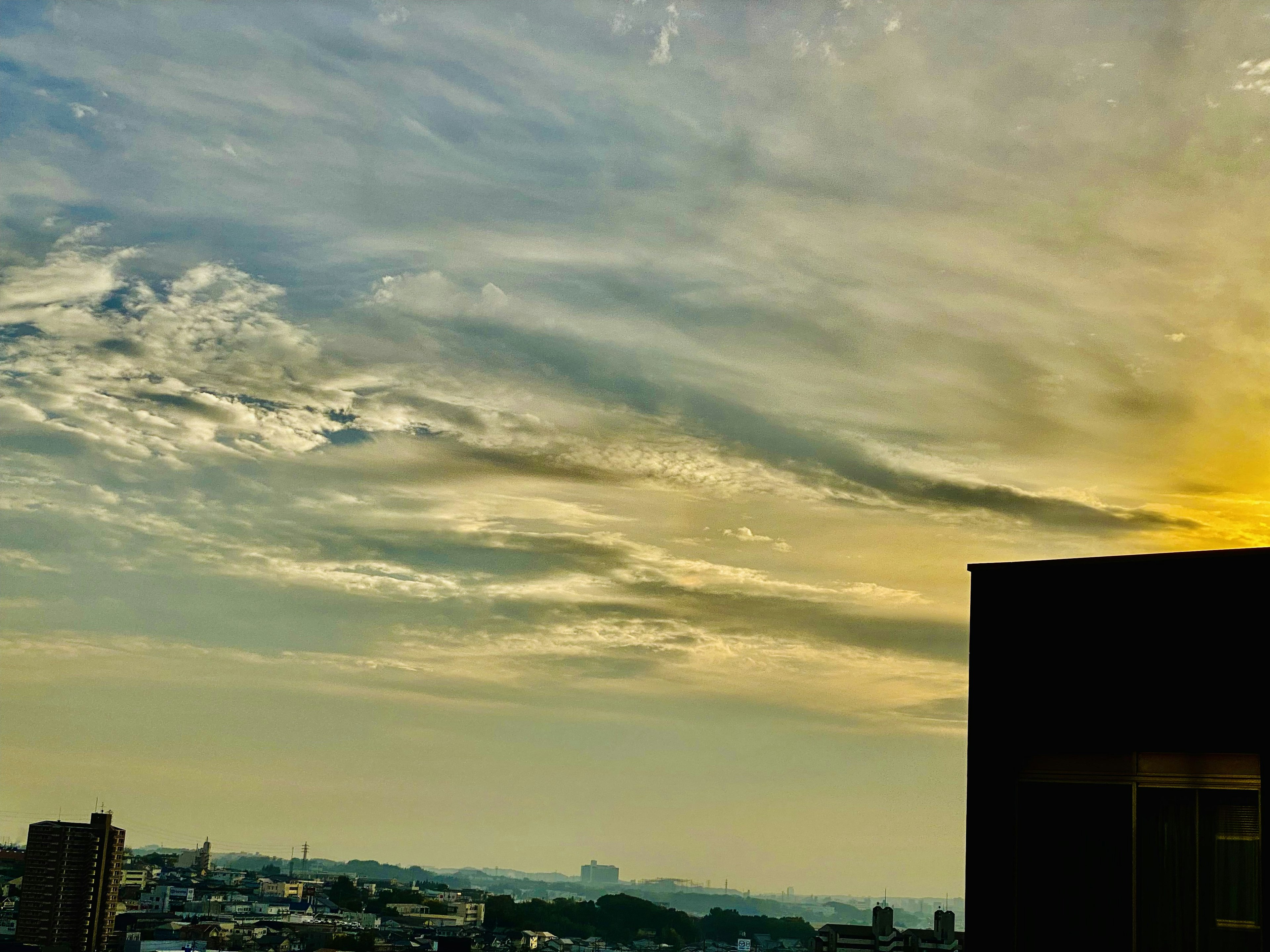 夕焼けの空と都市の景色が広がる