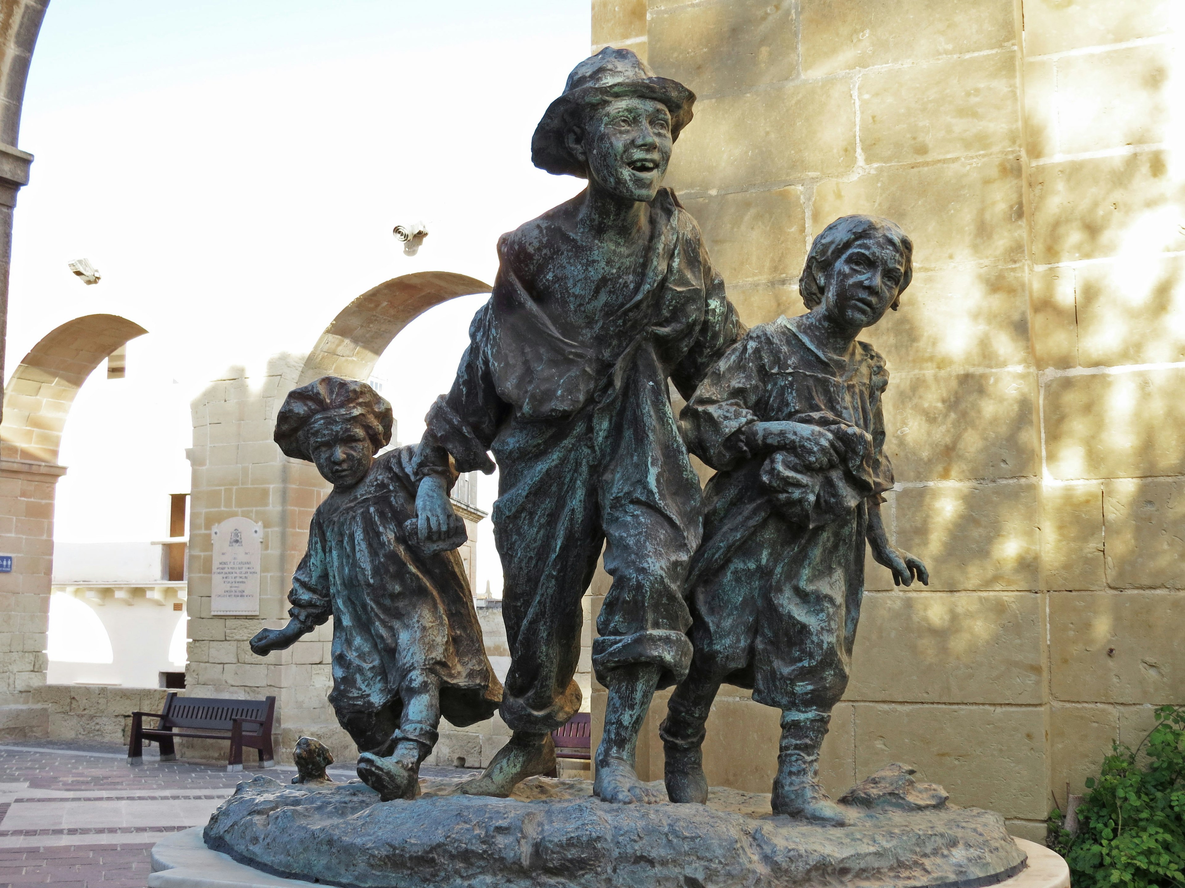 Estatua de bronce de niños caminando felices juntos