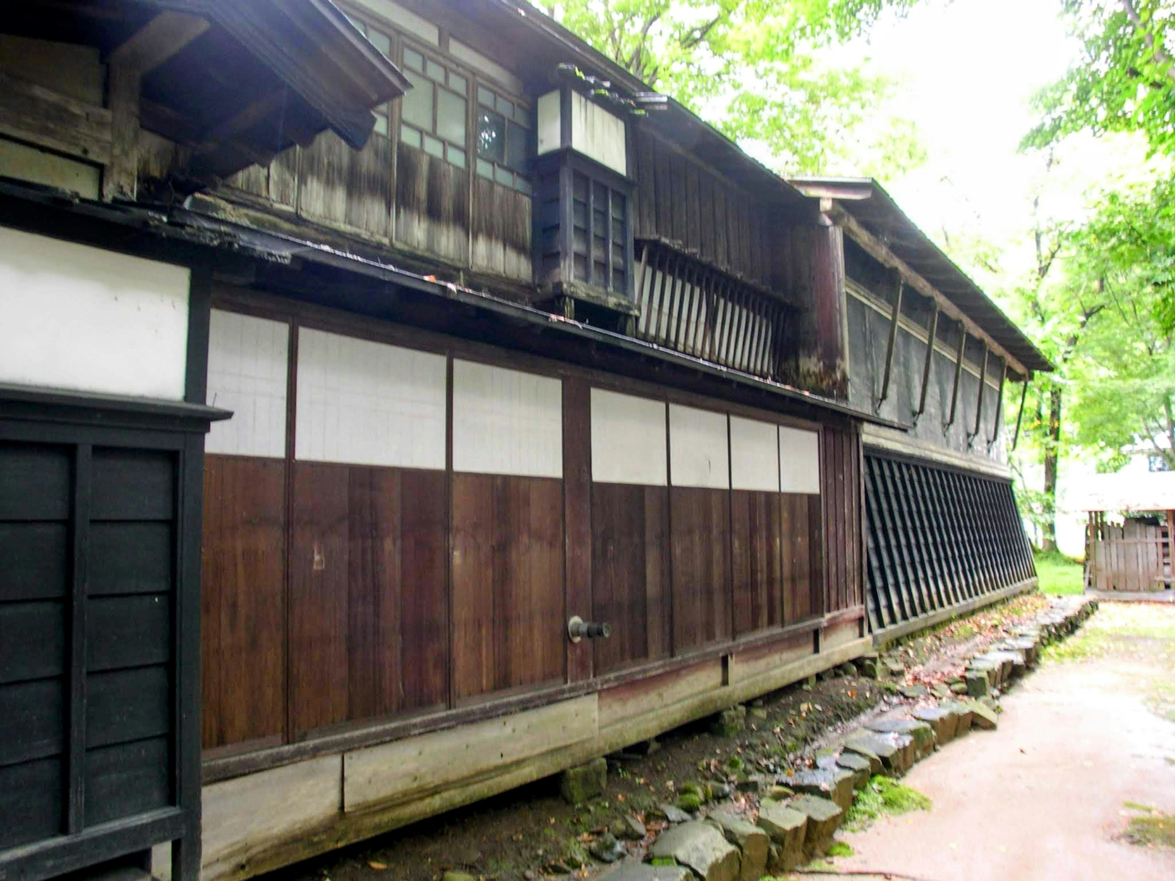 Exterior de un antiguo edificio japonés con paredes de madera y puertas corredizas blancas