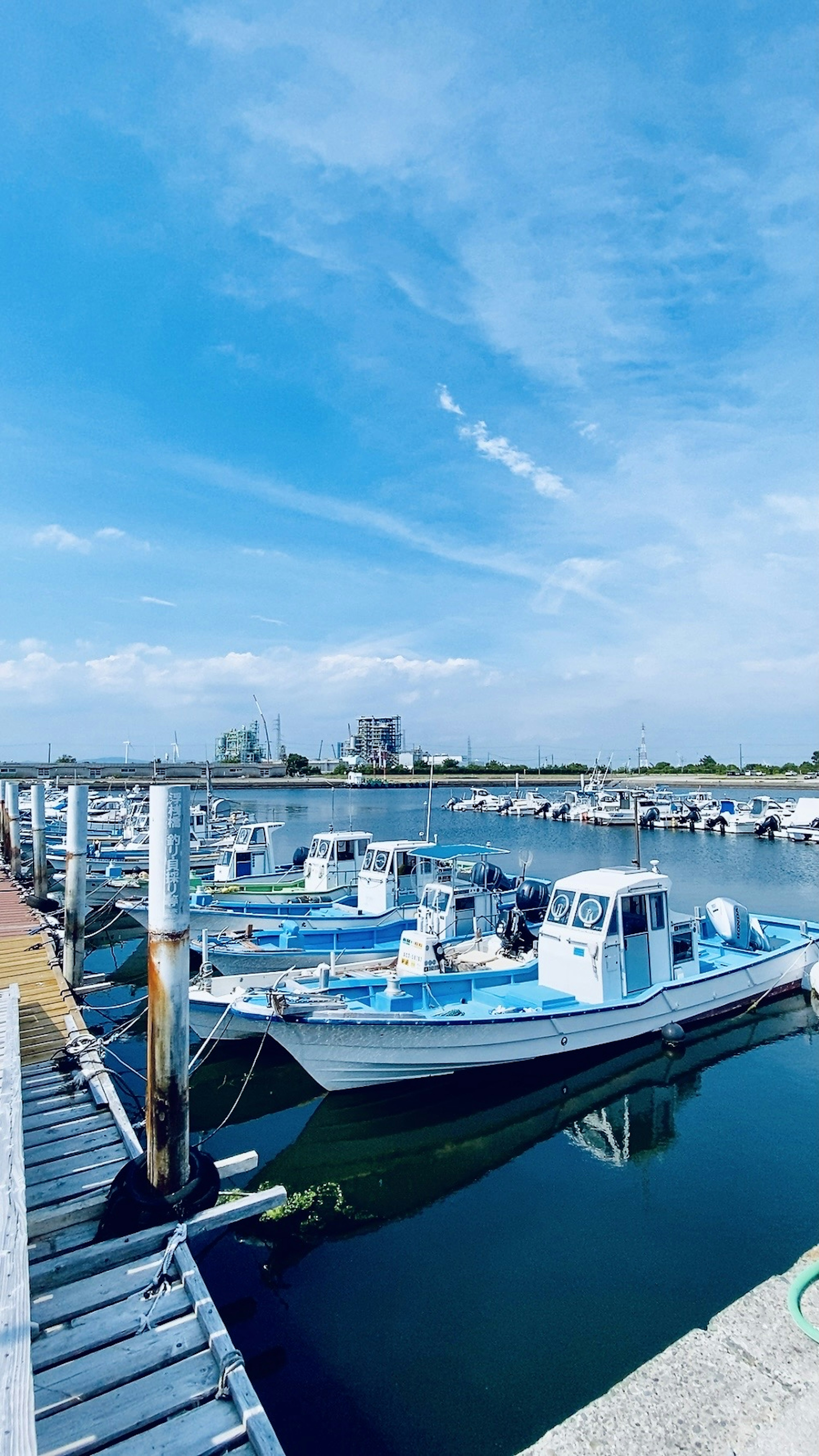 Escena de puerto con cielo azul y barcos atracados