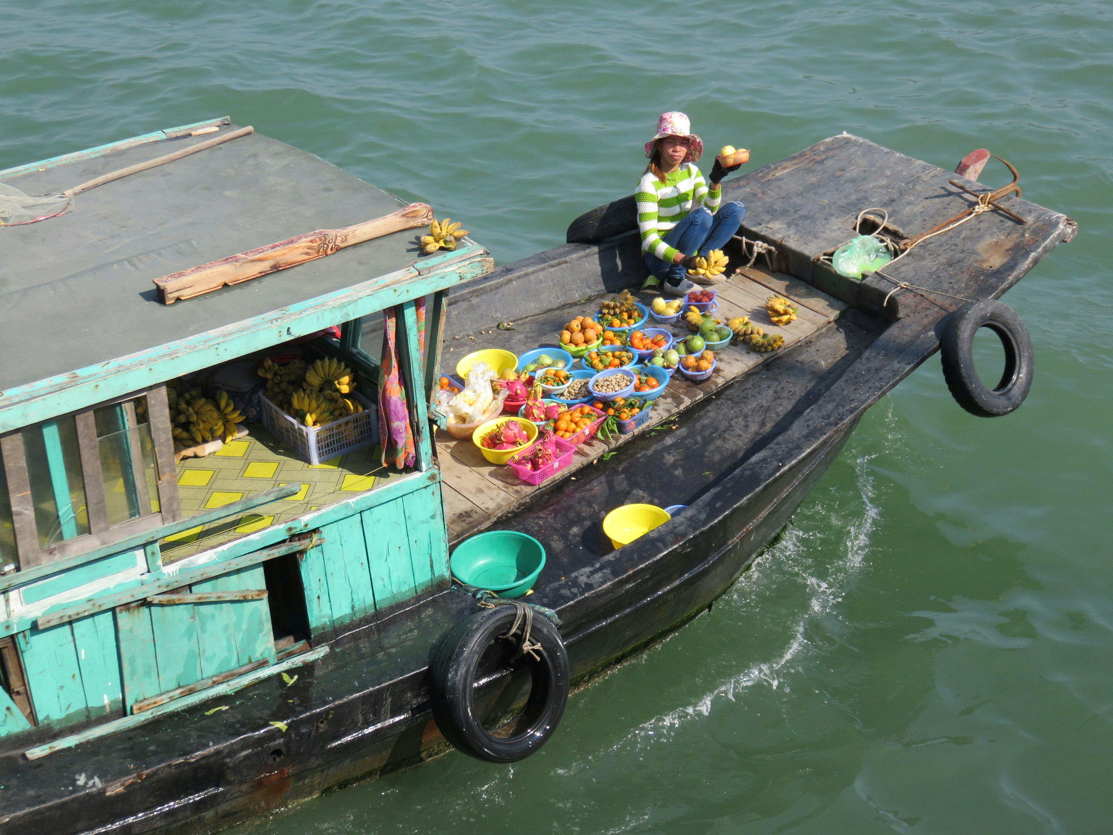 Frau, die bunte Früchte auf einem kleinen Boot verkauft