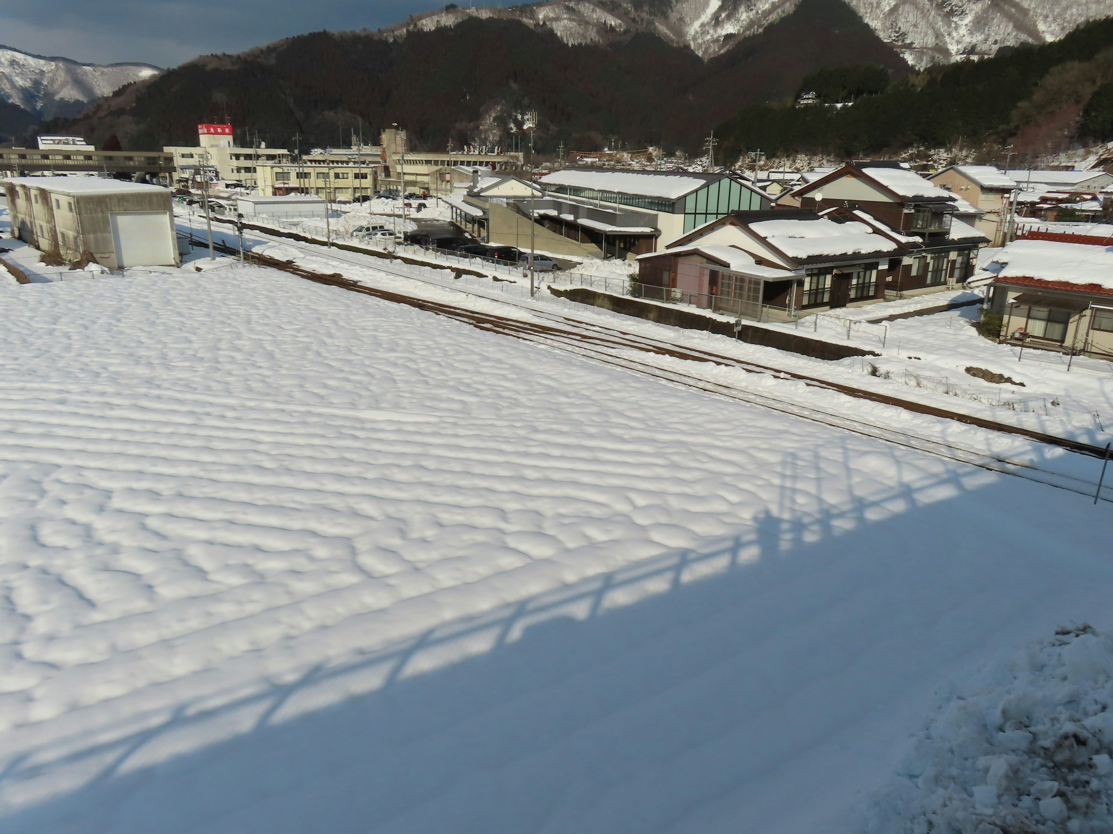 Schneebedeckte Felder und Berge im Hintergrund