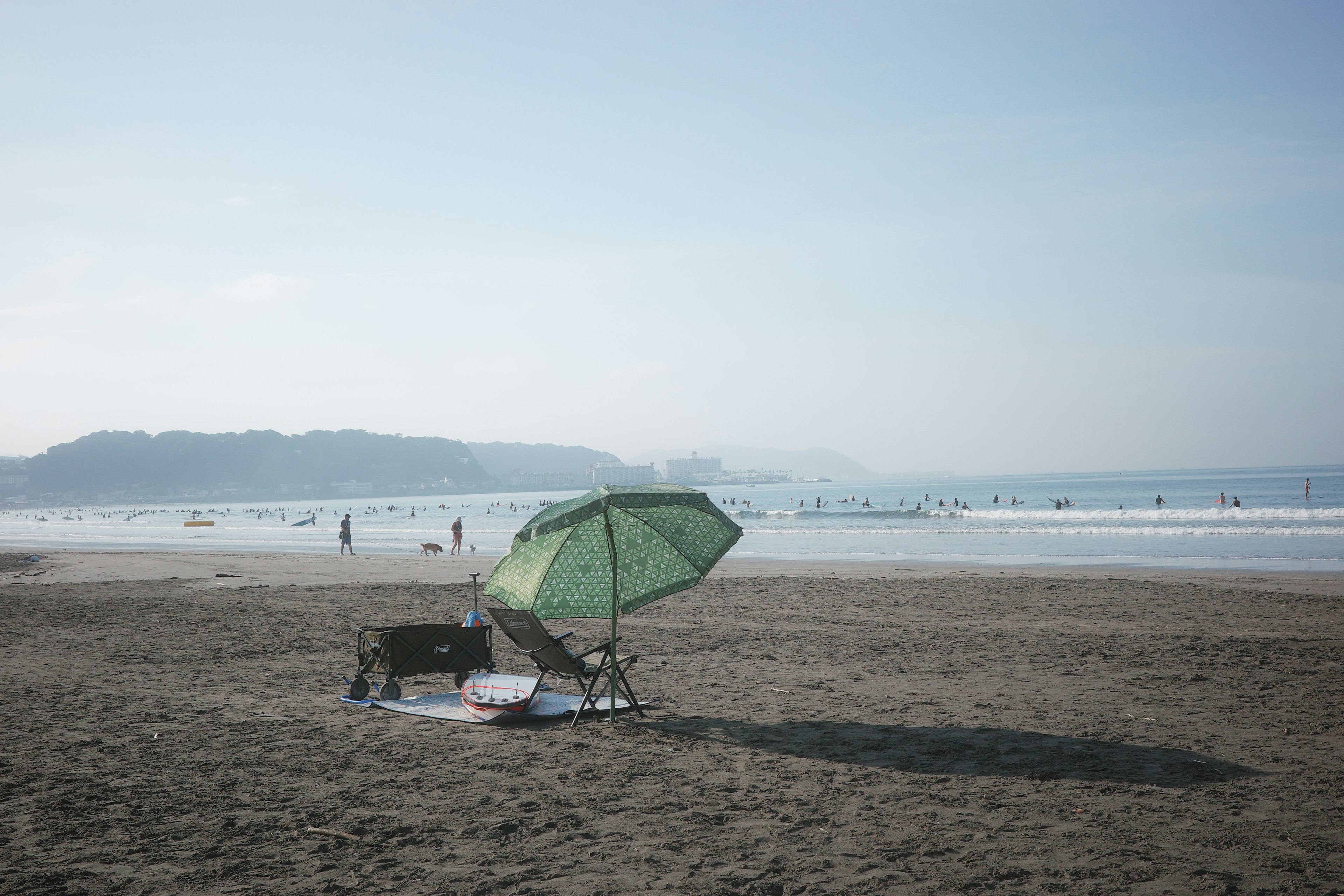 海灘場景，帶有綠色傘和沙灘椅