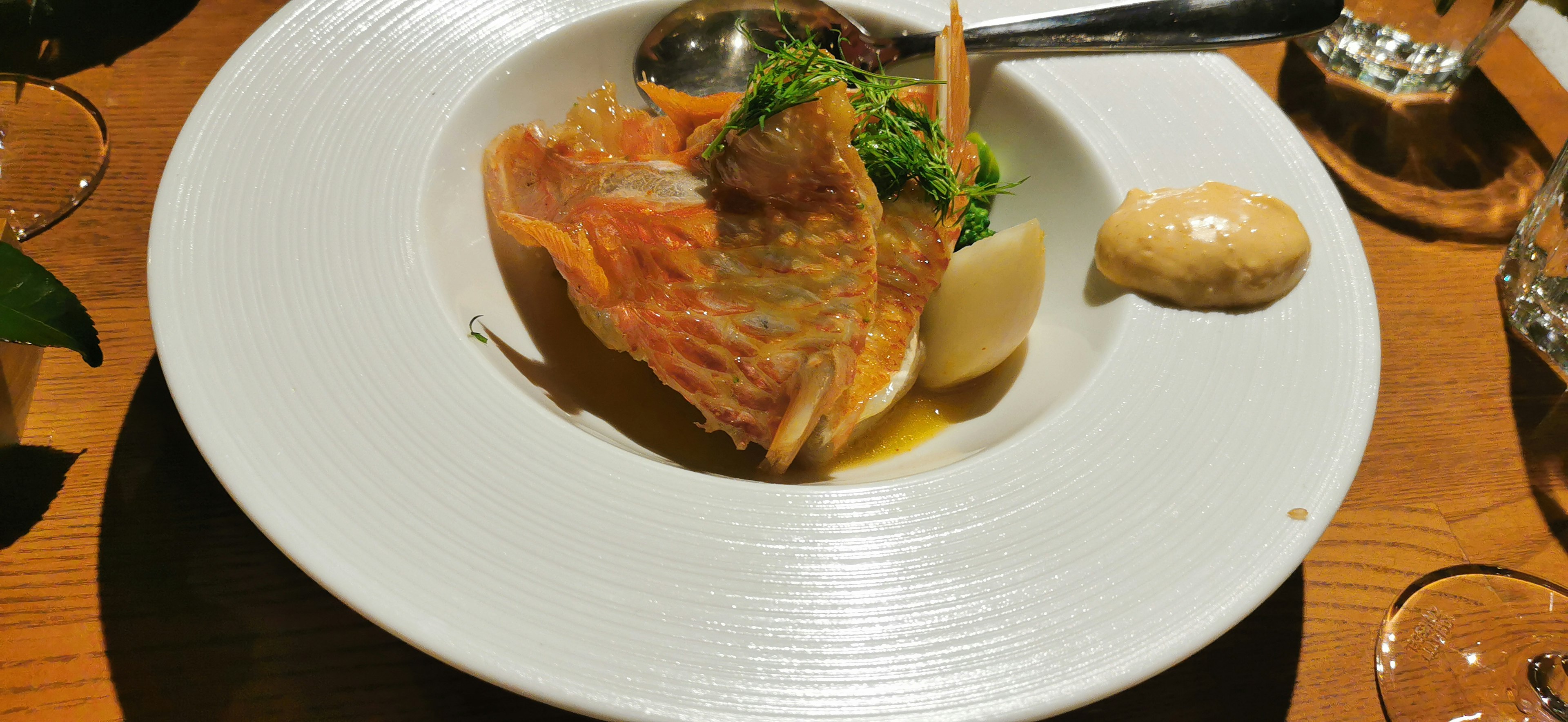 Plato de pescado bellamente presentado con verduras de acompañamiento