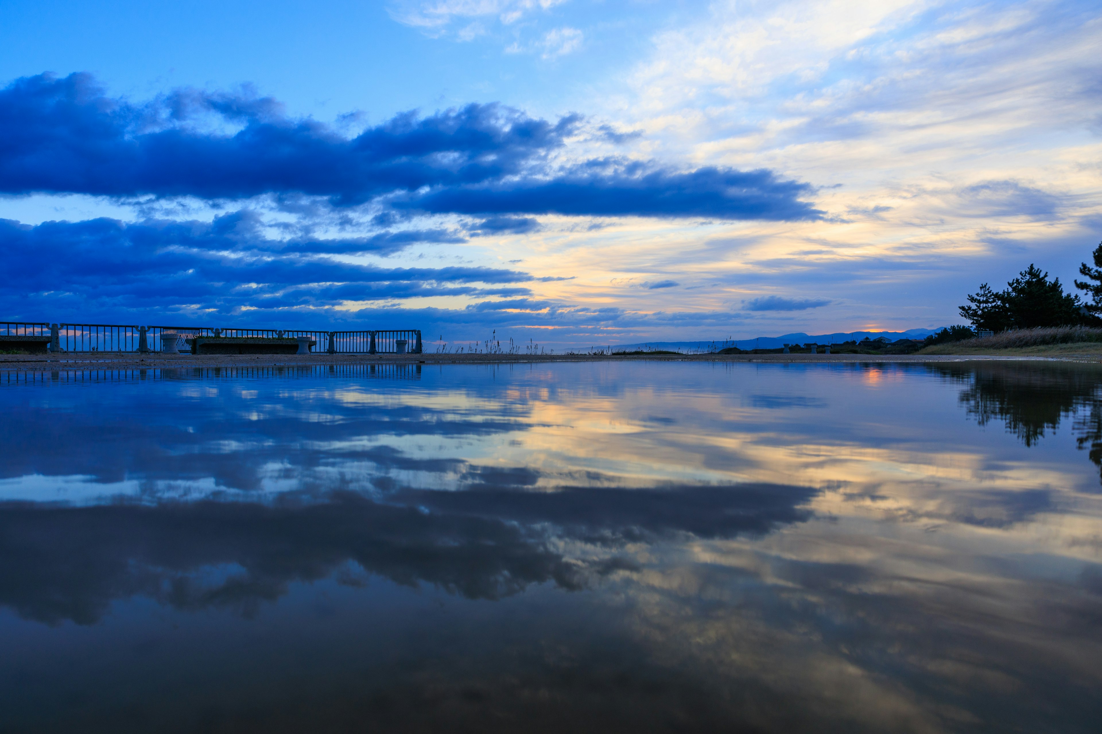 Lago sereno che riflette un bel cielo blu e nuvole