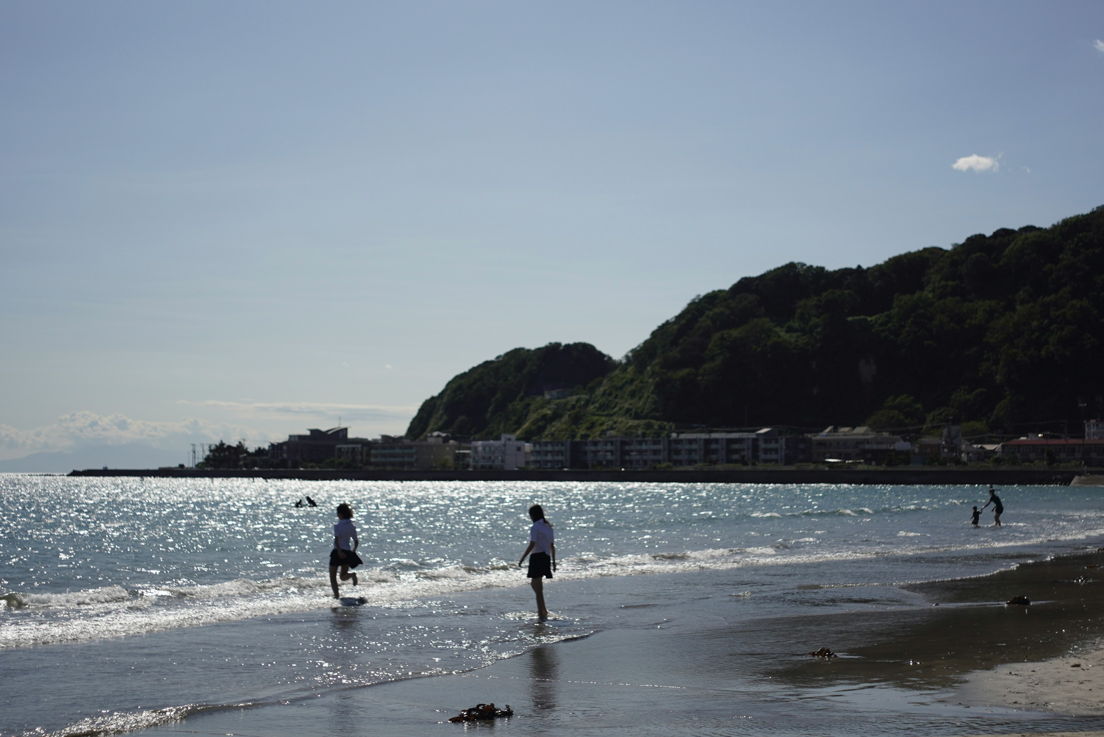 Des gens jouant sur la plage avec des vagues douces