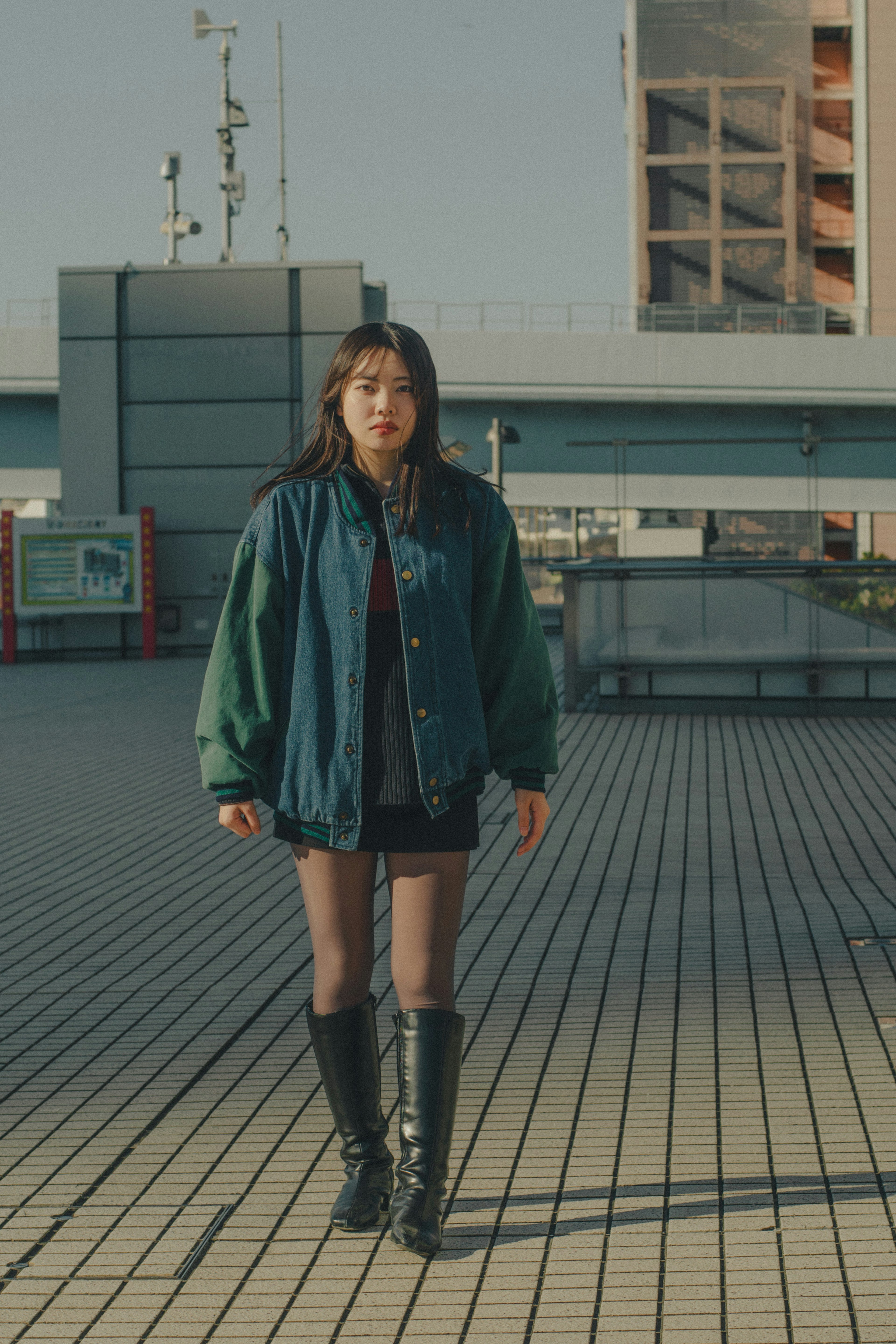 Woman wearing a blue and green jacket standing outdoors