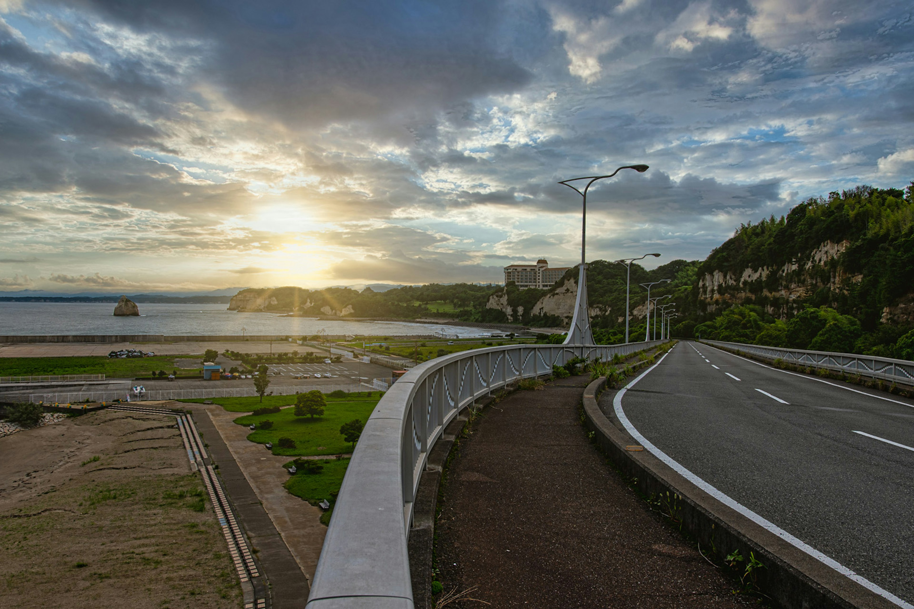 夕日が輝く海岸線沿いの道路と緑の風景