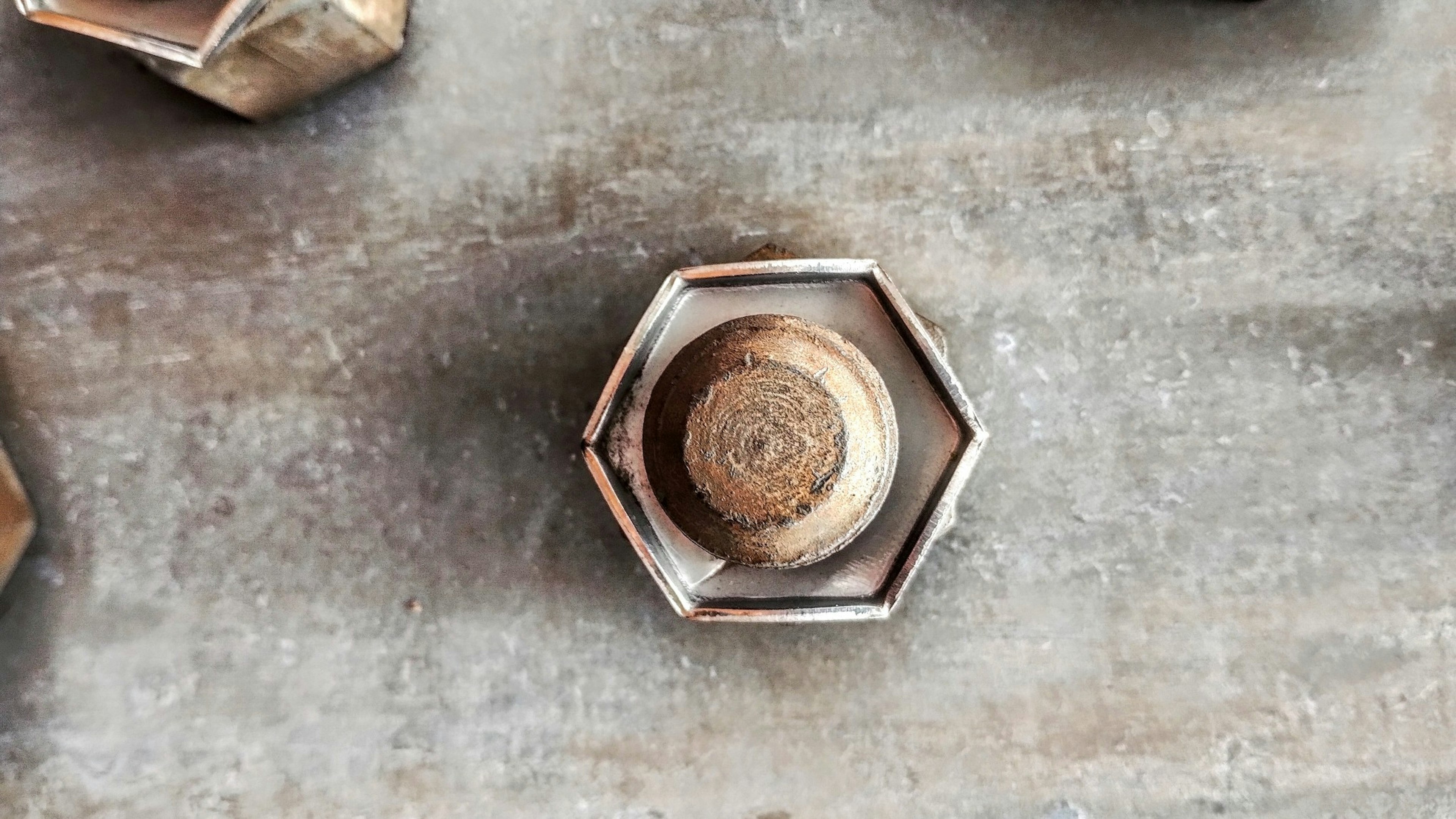 Bouton en métal hexagonal placé sur une surface