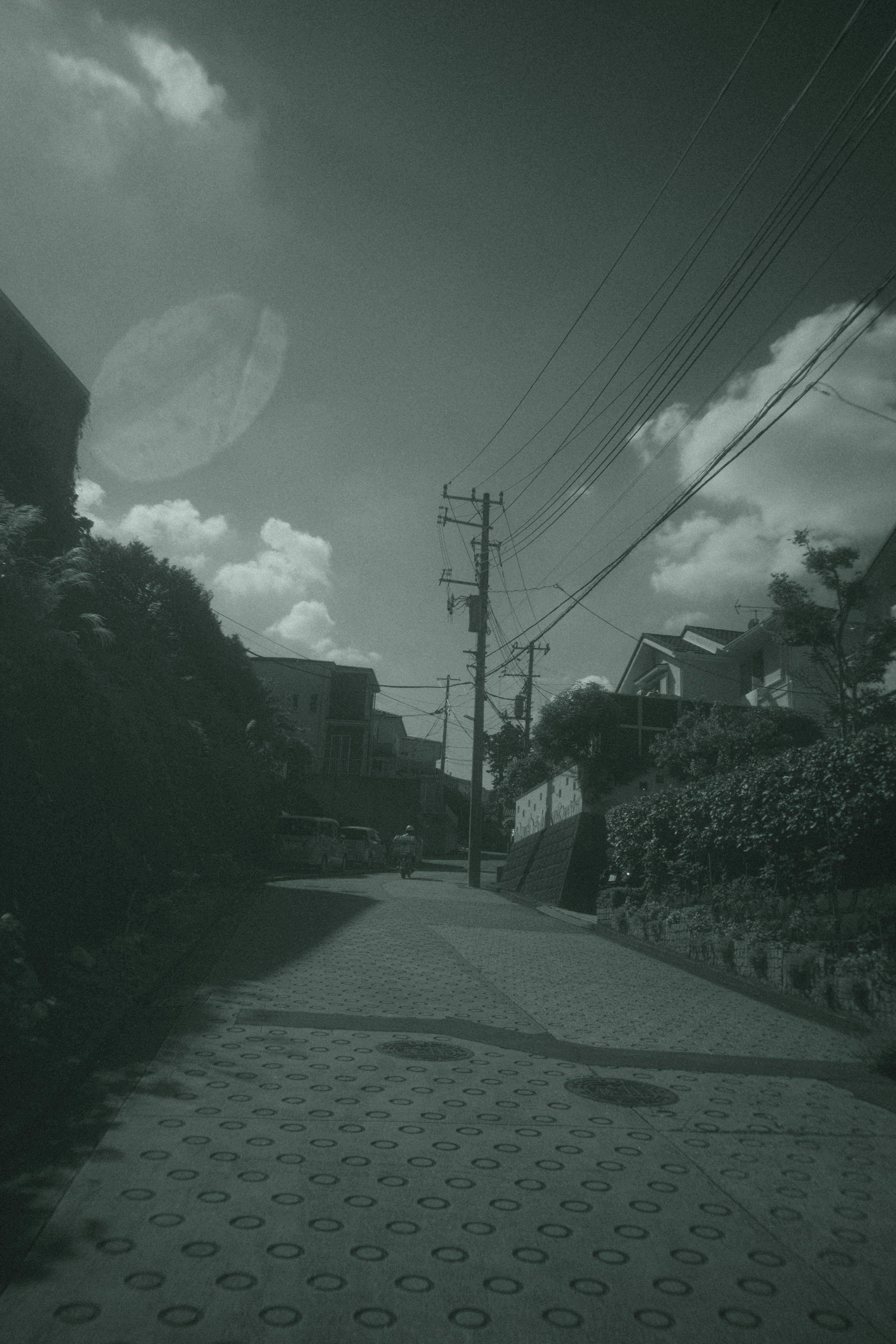 Dark street scene with utility poles and blue sky