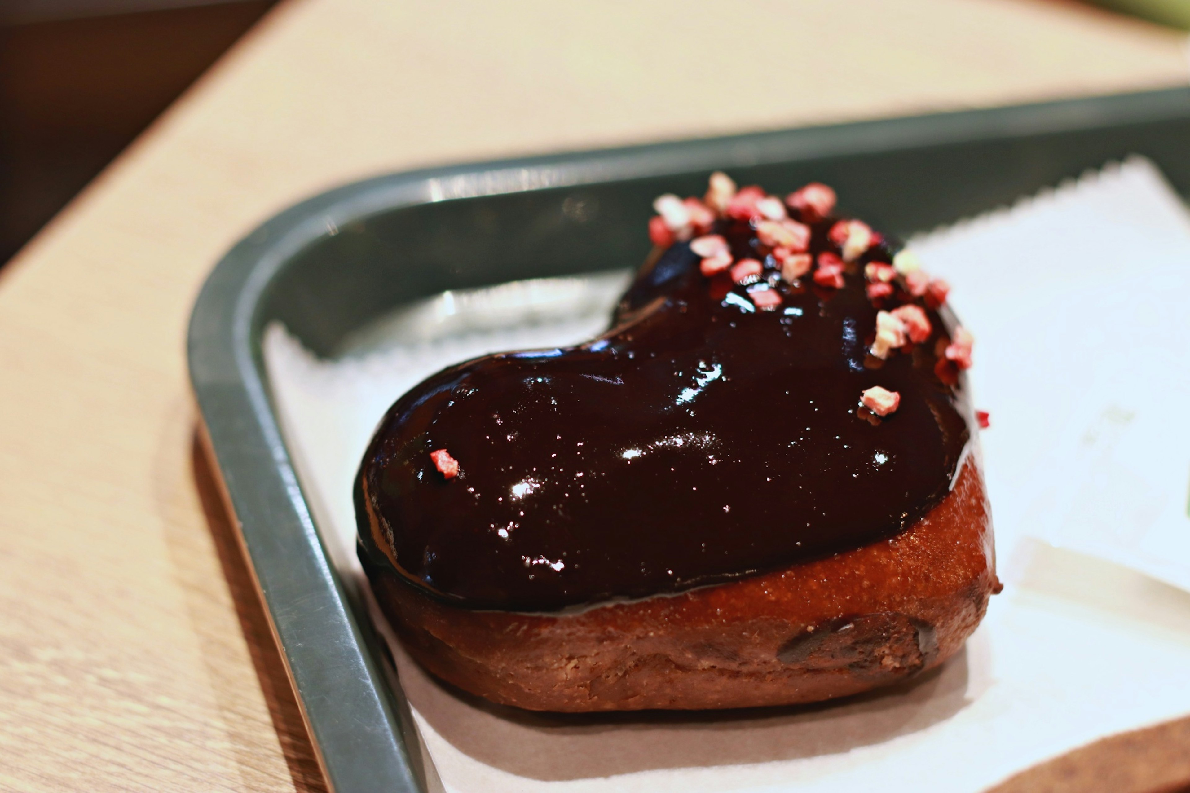 Heart-shaped chocolate donut topped with colorful sprinkles