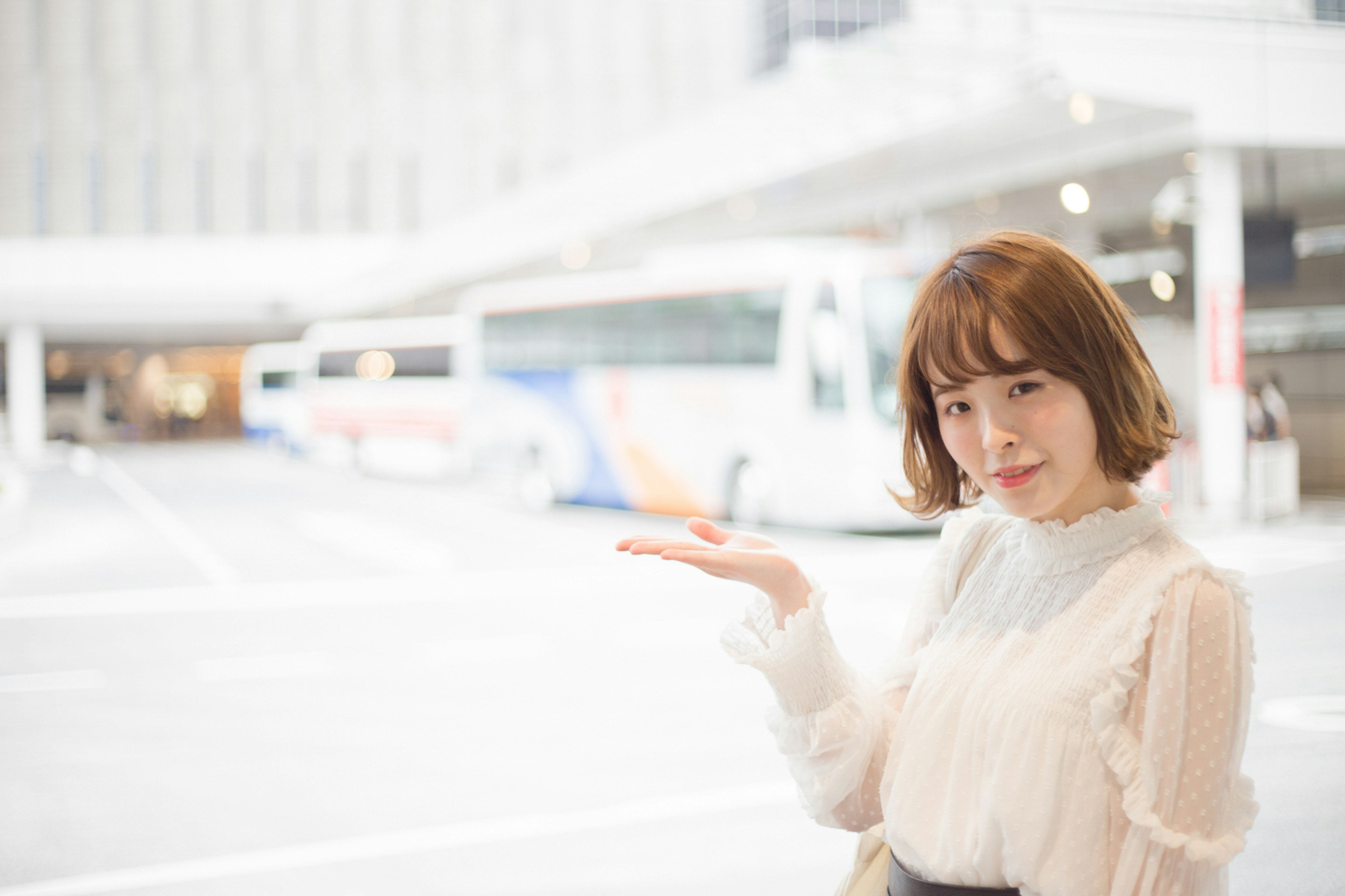 A woman gesturing with her hand in a bright background