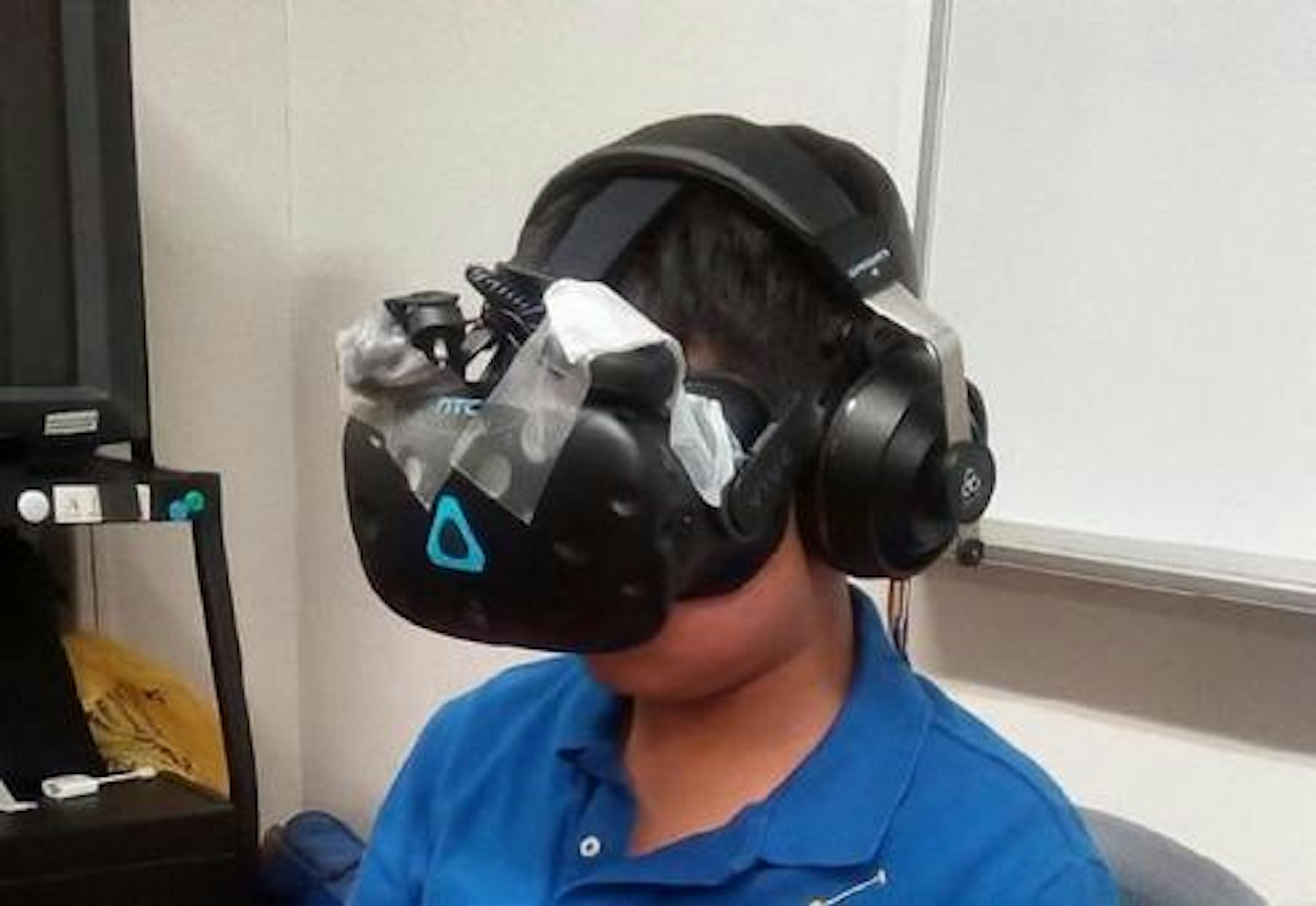 Seorang anak mengenakan headset VR dengan headphone