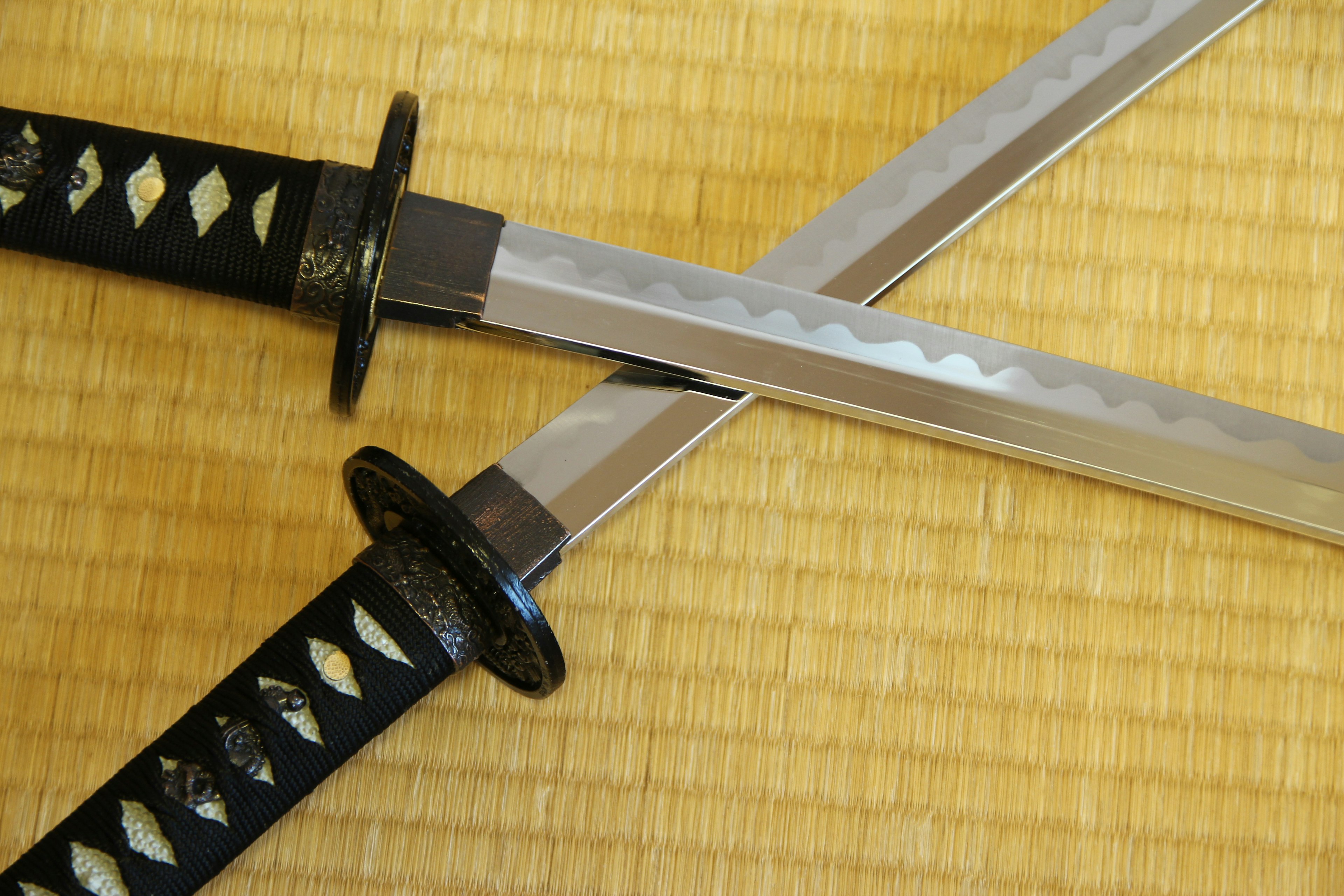 Two Japanese swords crossed on a tatami mat background