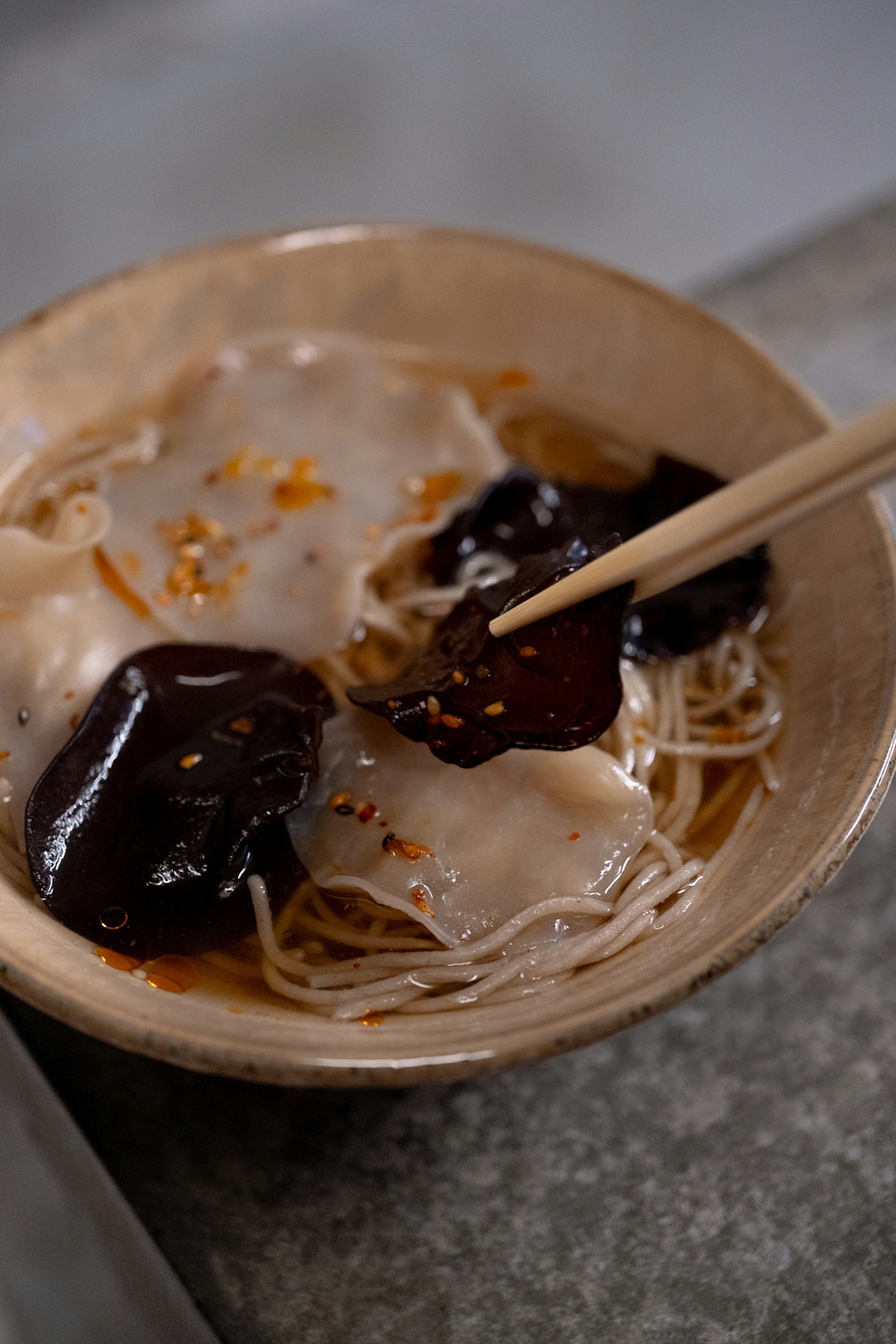 皿に盛られた麺と黒い具材のスープ