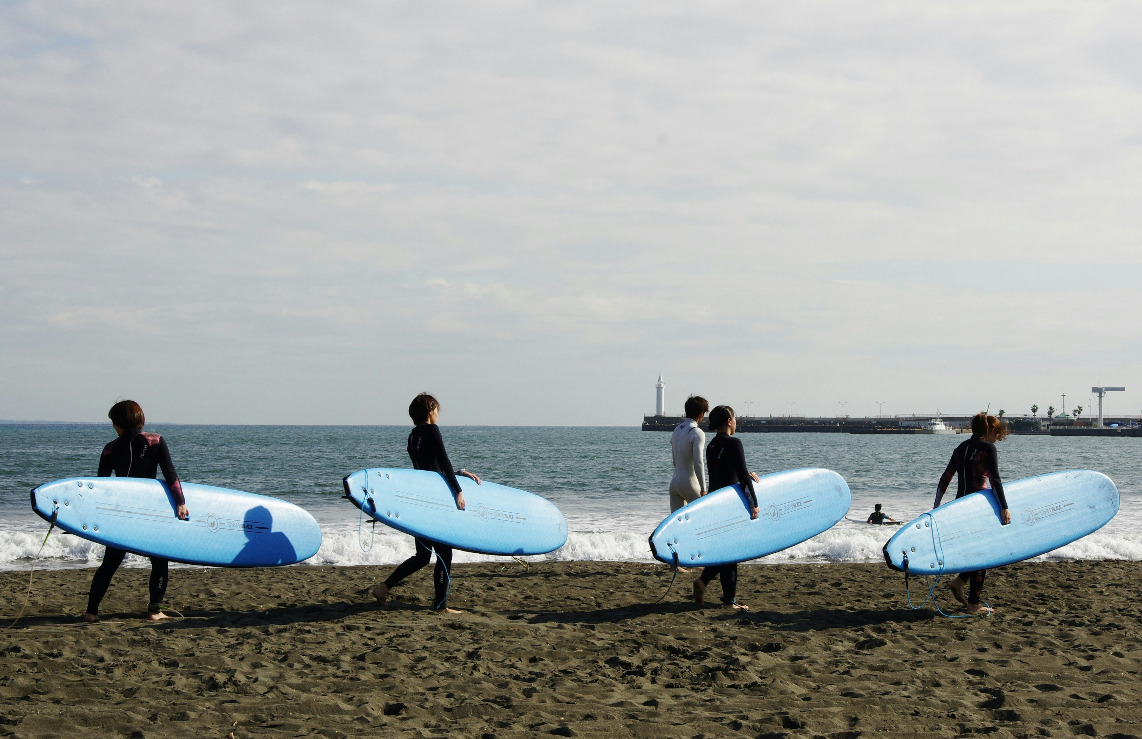 Personnes marchant sur la plage avec des planches de surf