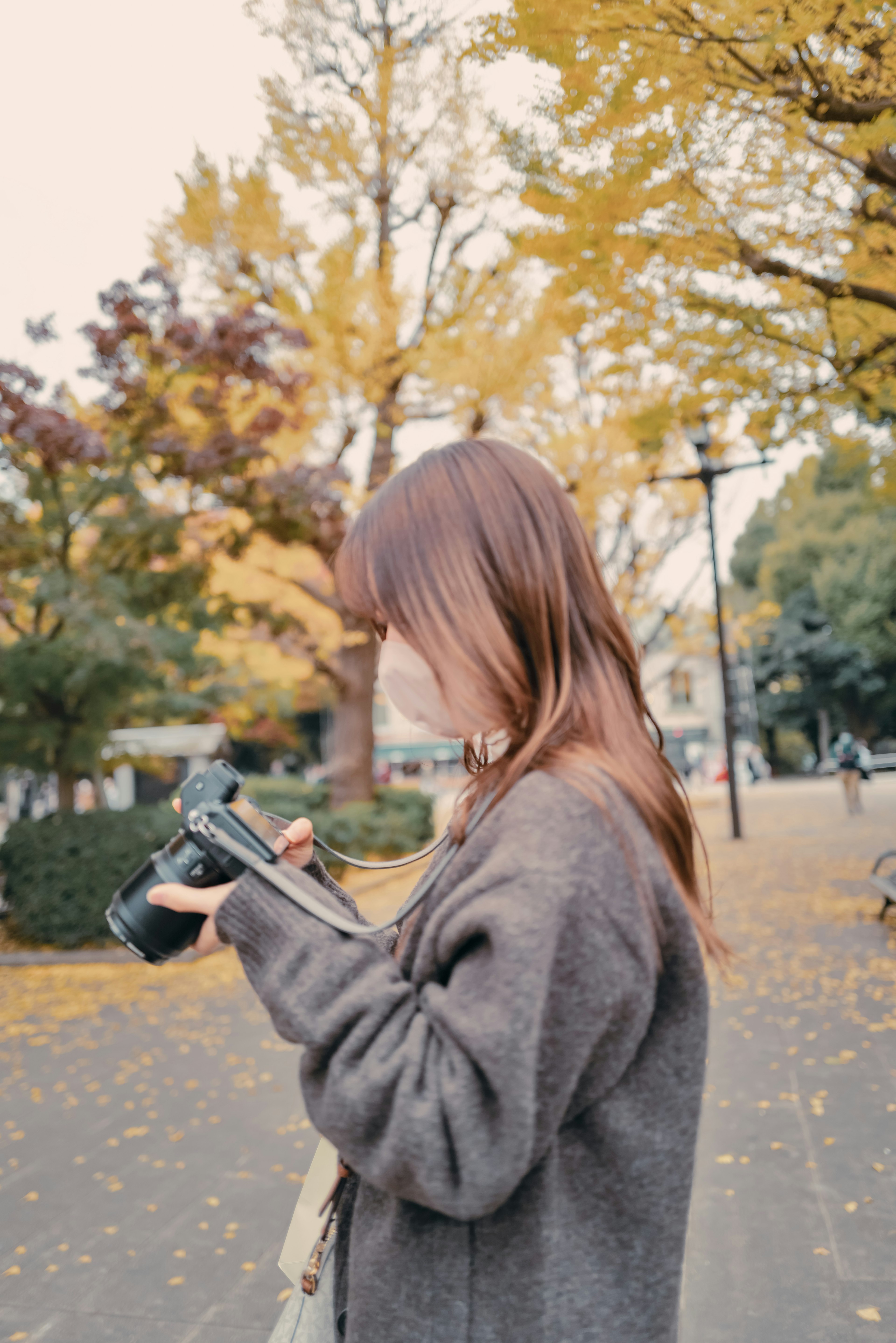 Donna con una macchina fotografica in un parco autunnale