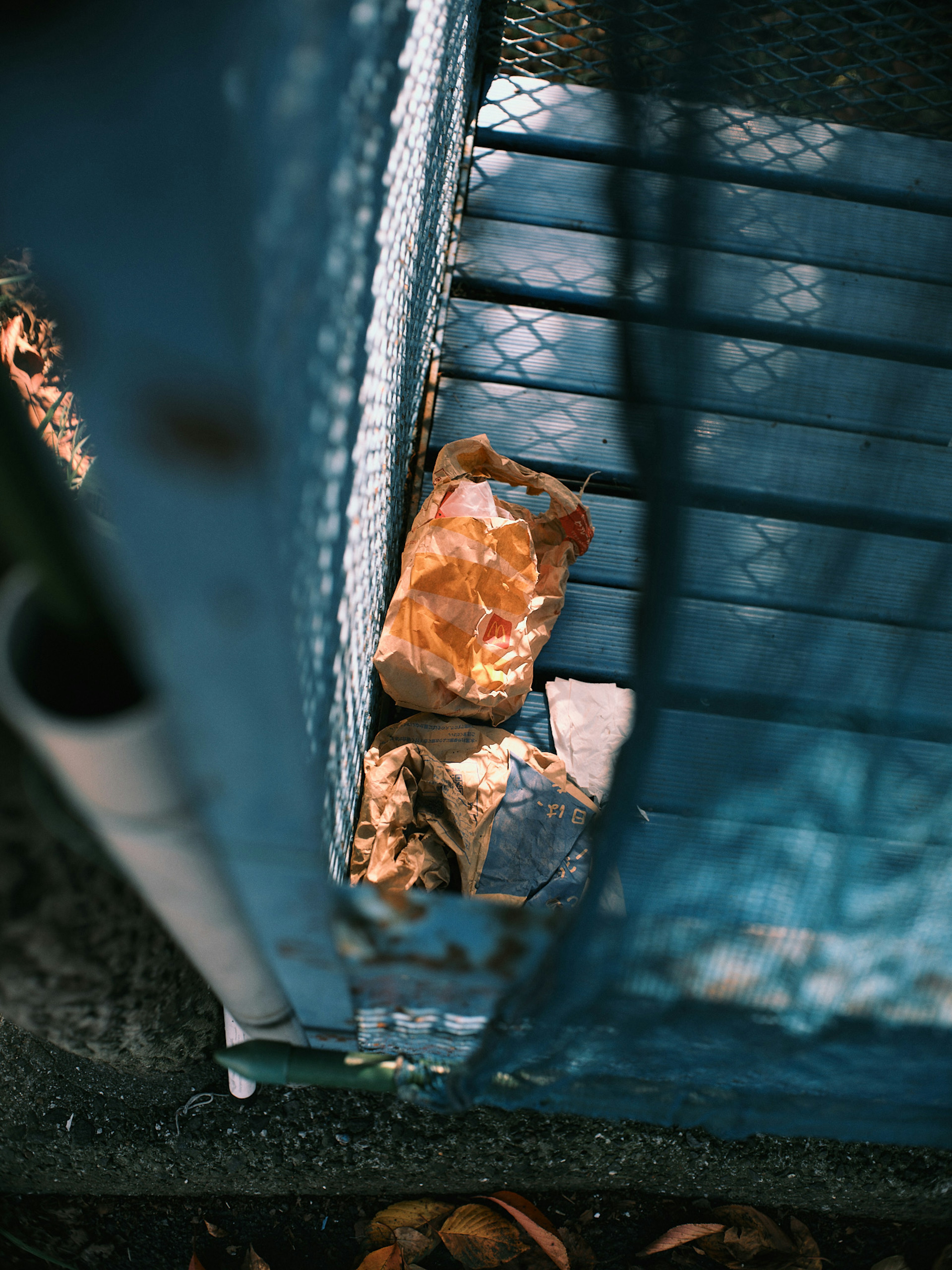 Vue d'un tas de déchets à travers une clôture bleue