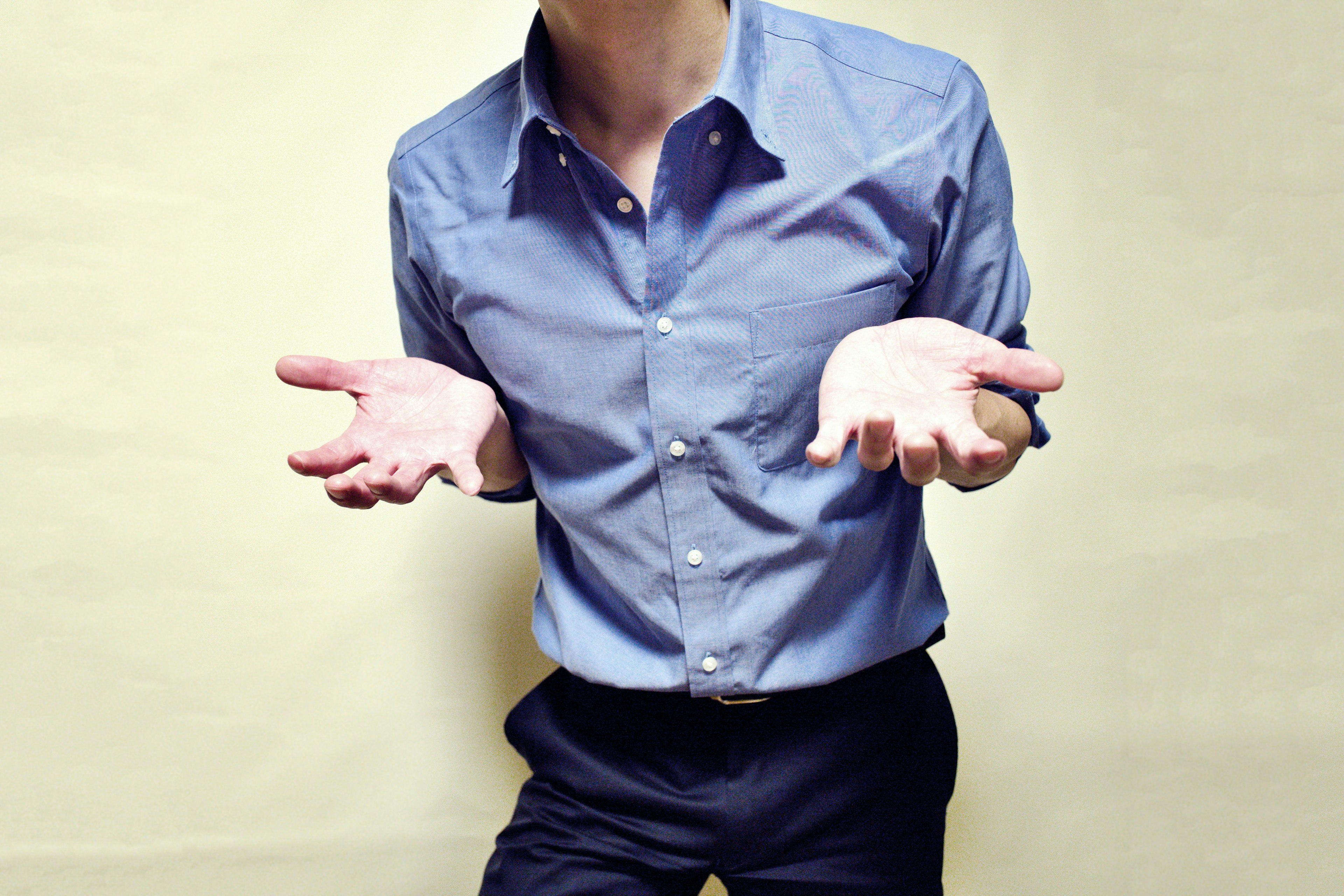 Homme en chemise bleue avec les mains étendues