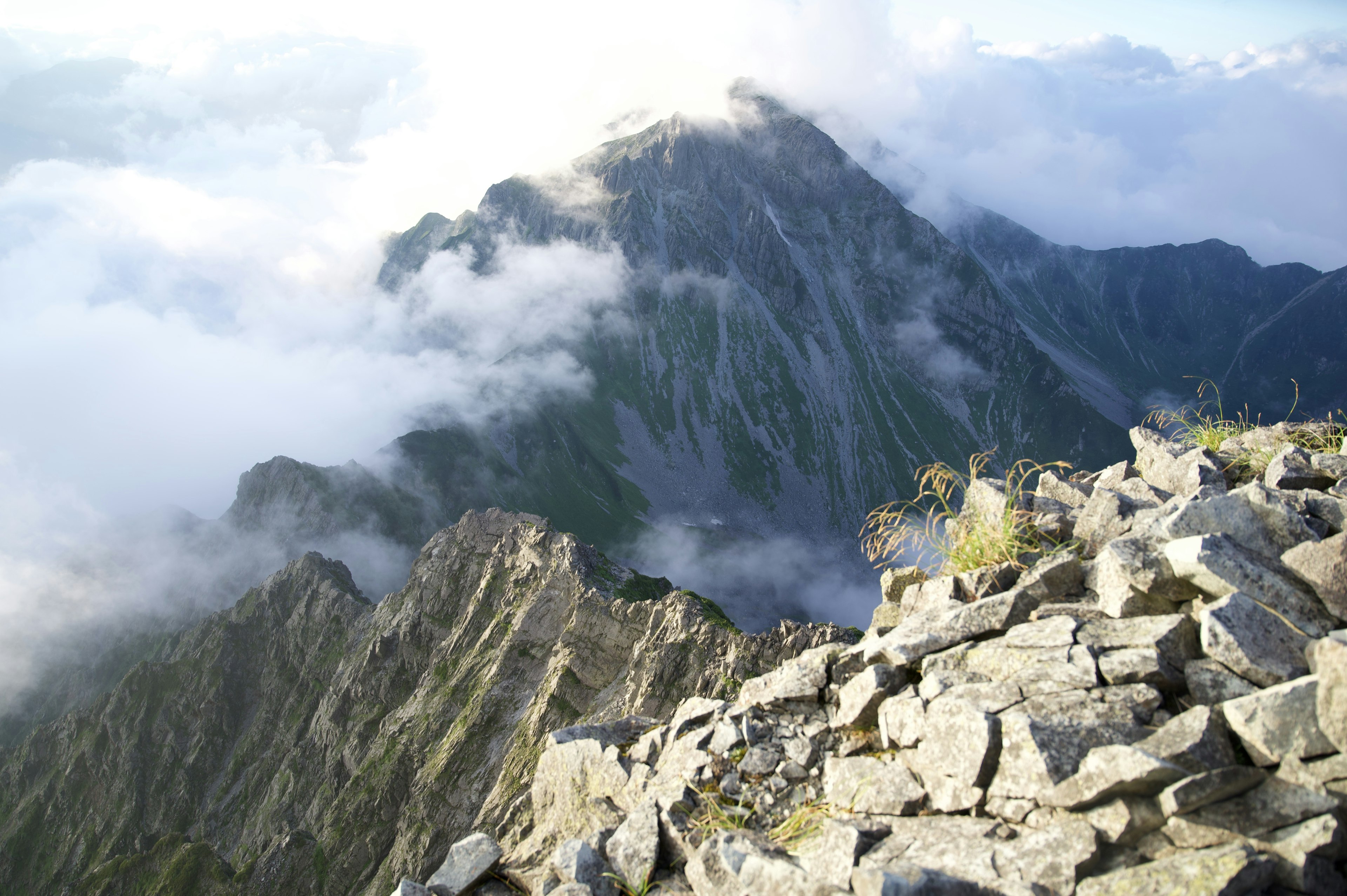 Paesaggio roccioso con montagne e nuvole sullo sfondo