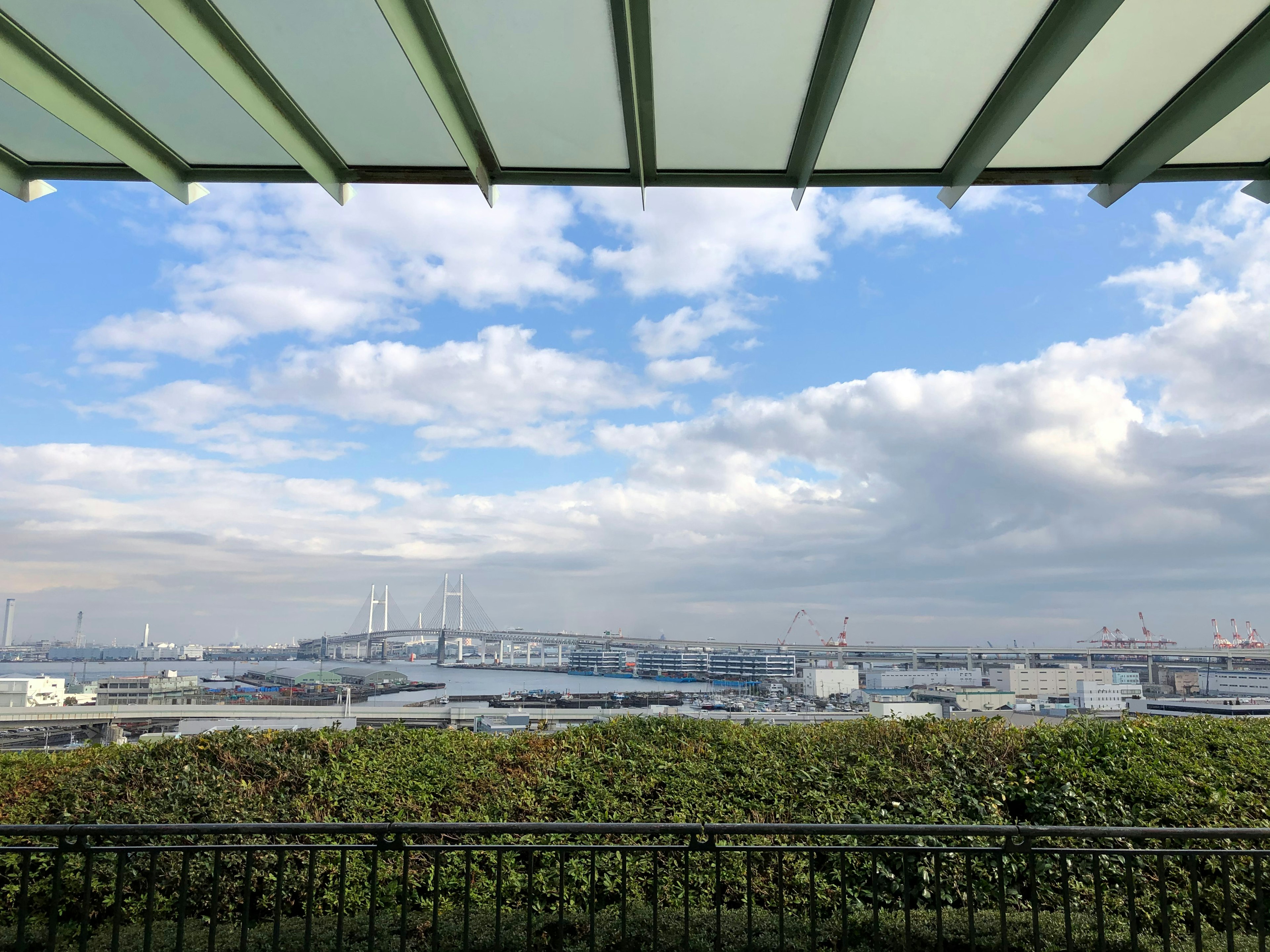 Eine malerische Aussicht mit blauem Himmel und Wolken sowie sichtbarem Grün und Gebäuden