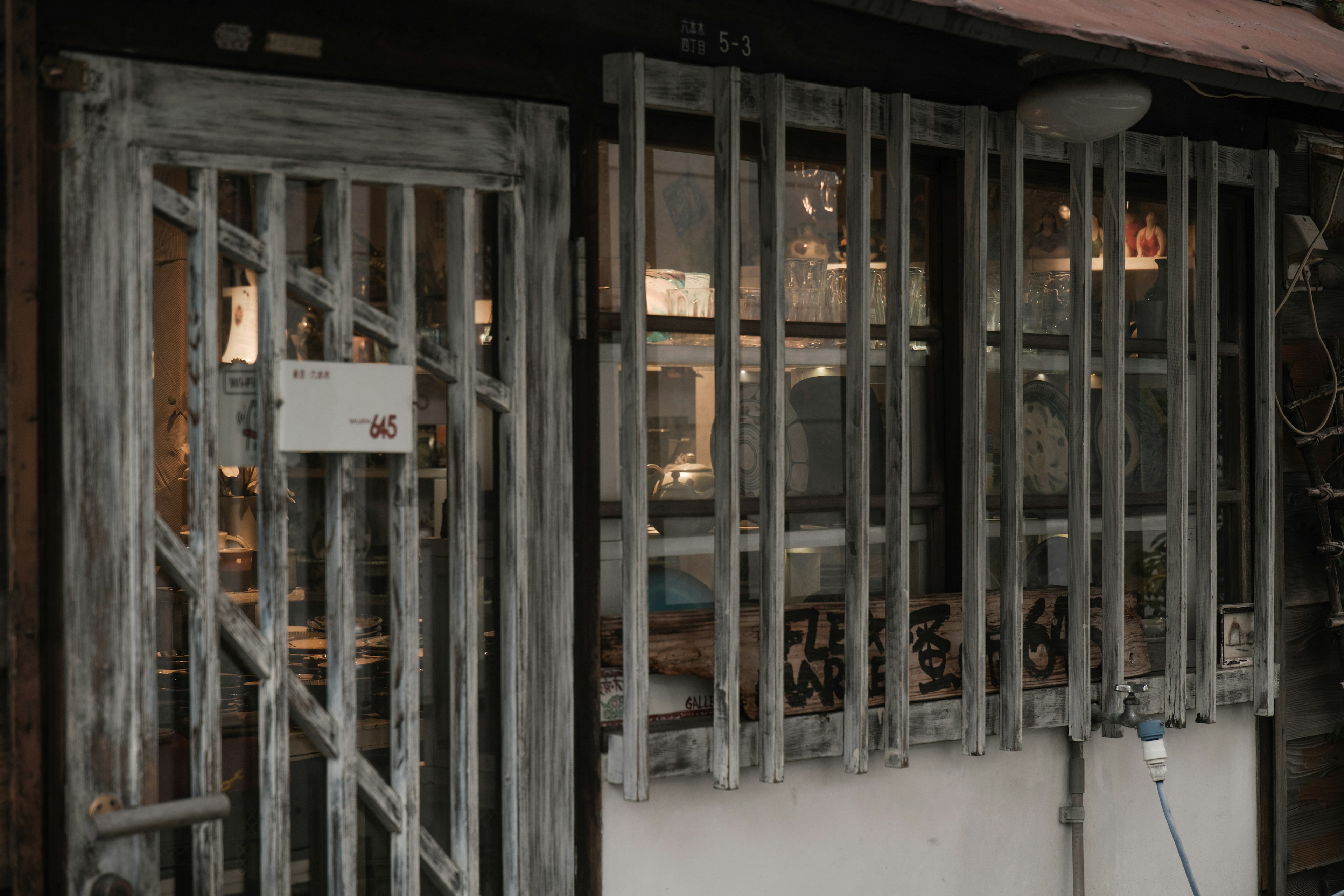 Exterior of a shop with an old wooden door and barred windows