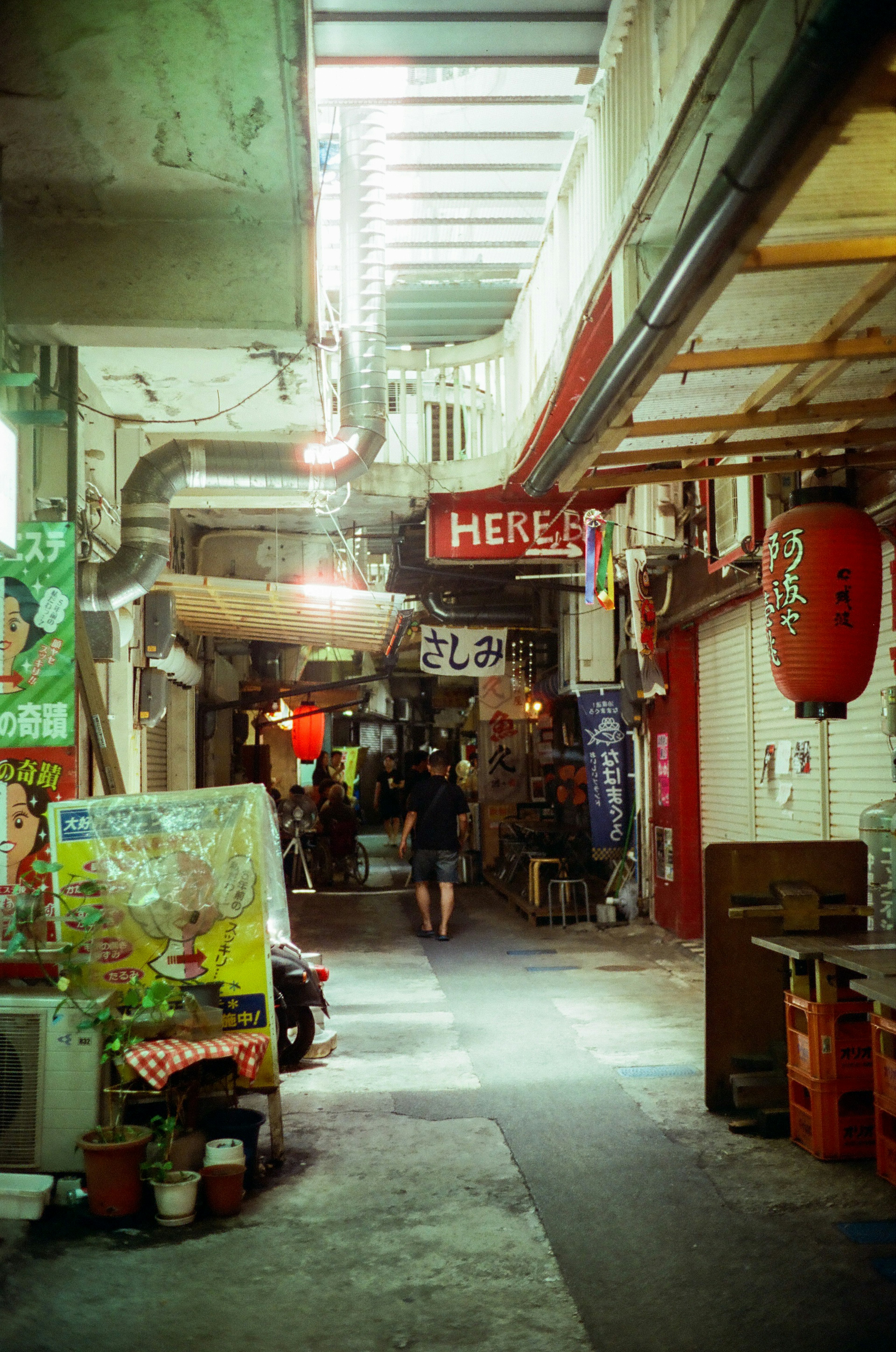 Narrow alley featuring shops and red lanterns in a market