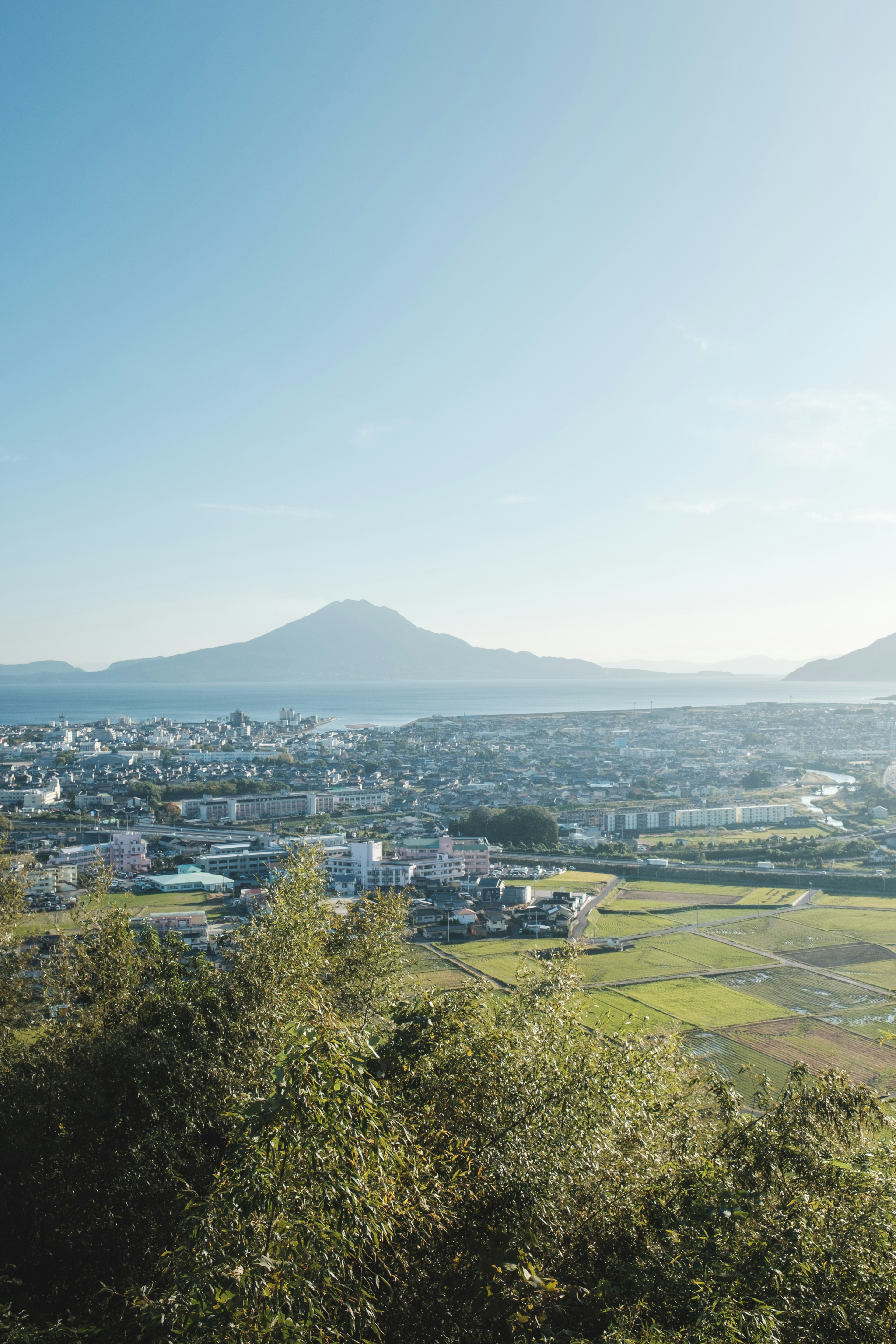 青空と山々を背景に広がる田園風景と町の眺め