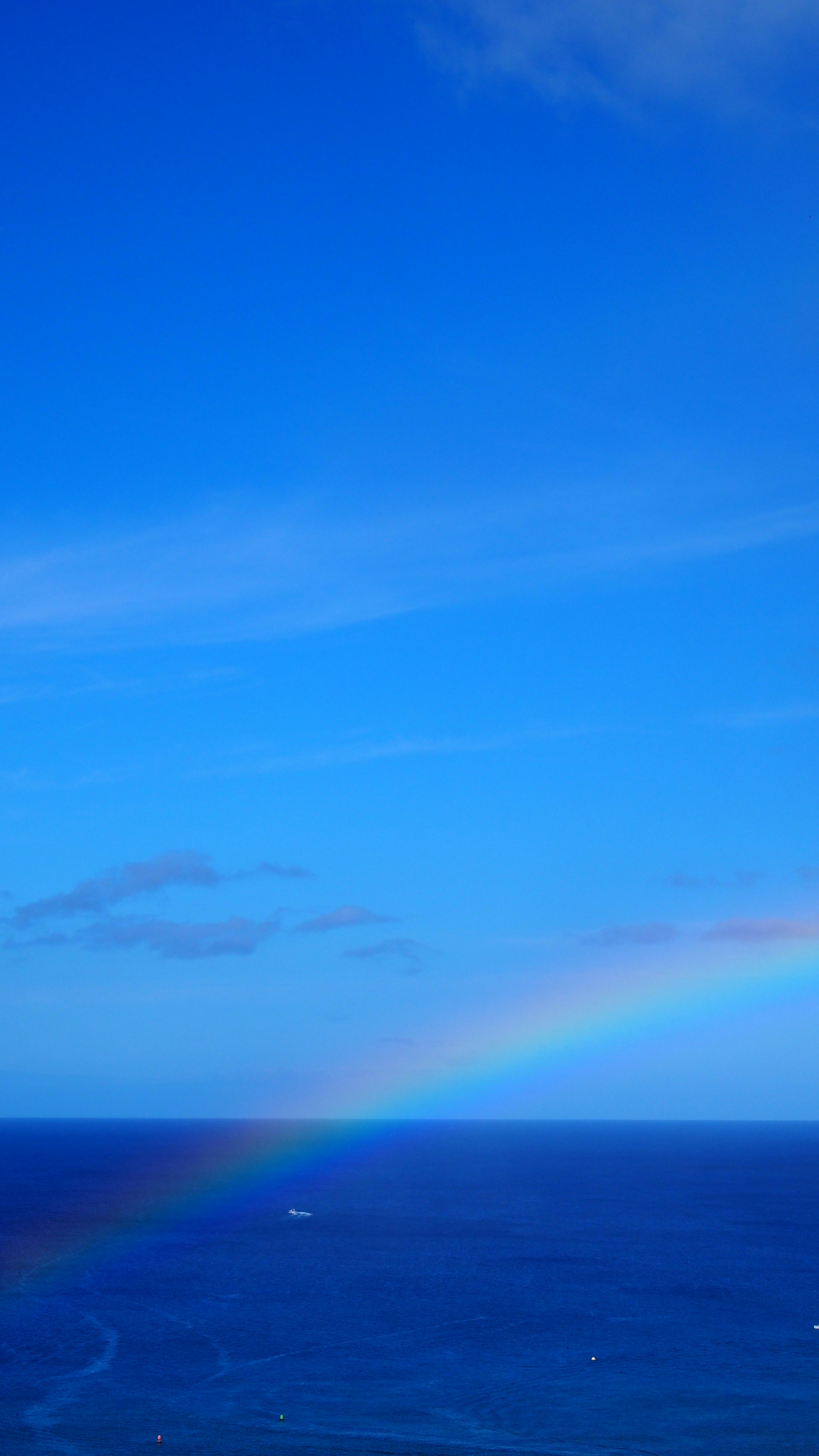 Arc-en-ciel au-dessus d'un océan bleu sous un ciel dégagé