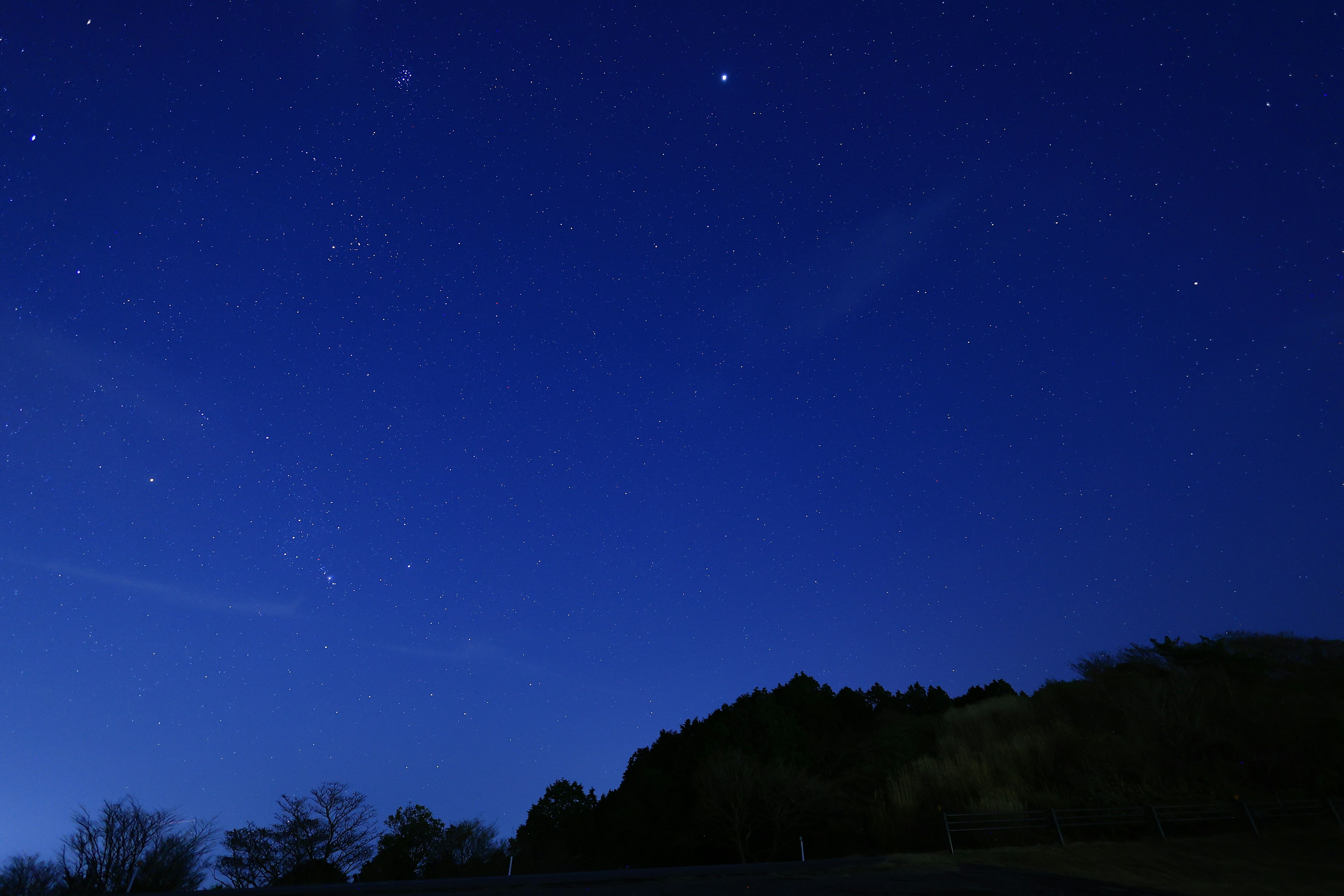 Cielo stellato sopra una collina scura con stelle sparse