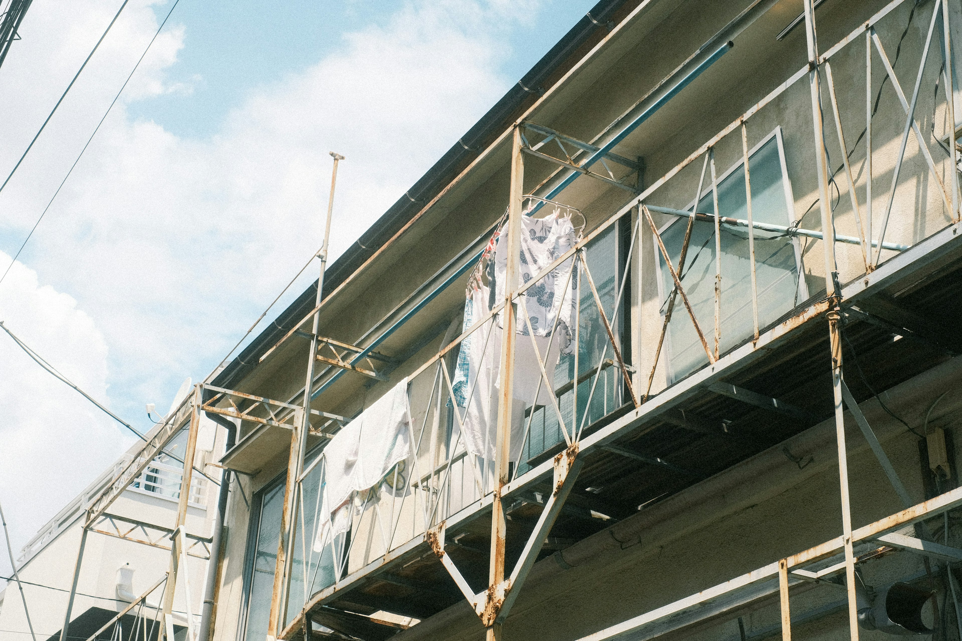 建物の外壁工事中の様子 scaffoldingと青空が見える