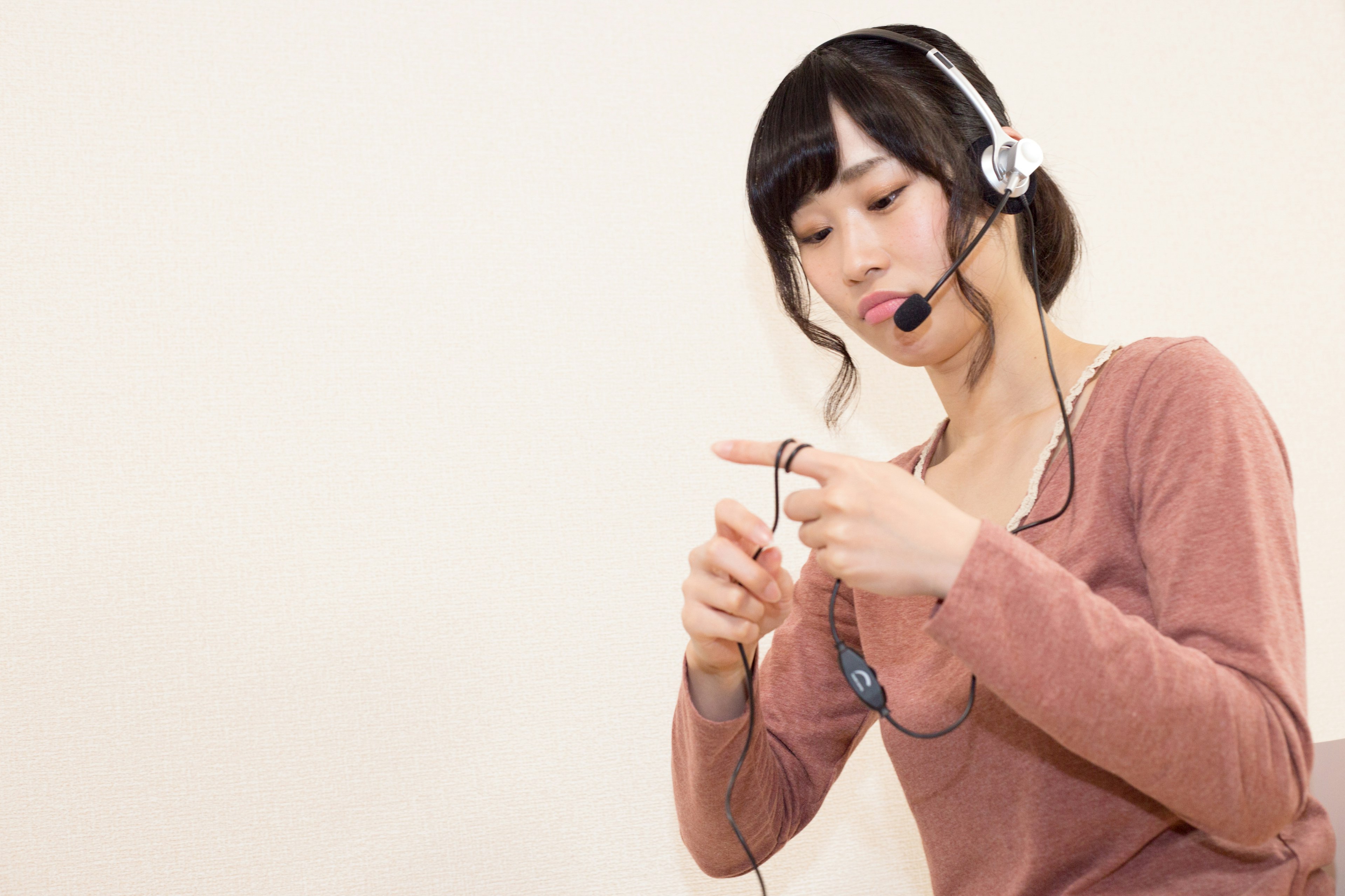 Frau mit Headset, die ein Kabel hält