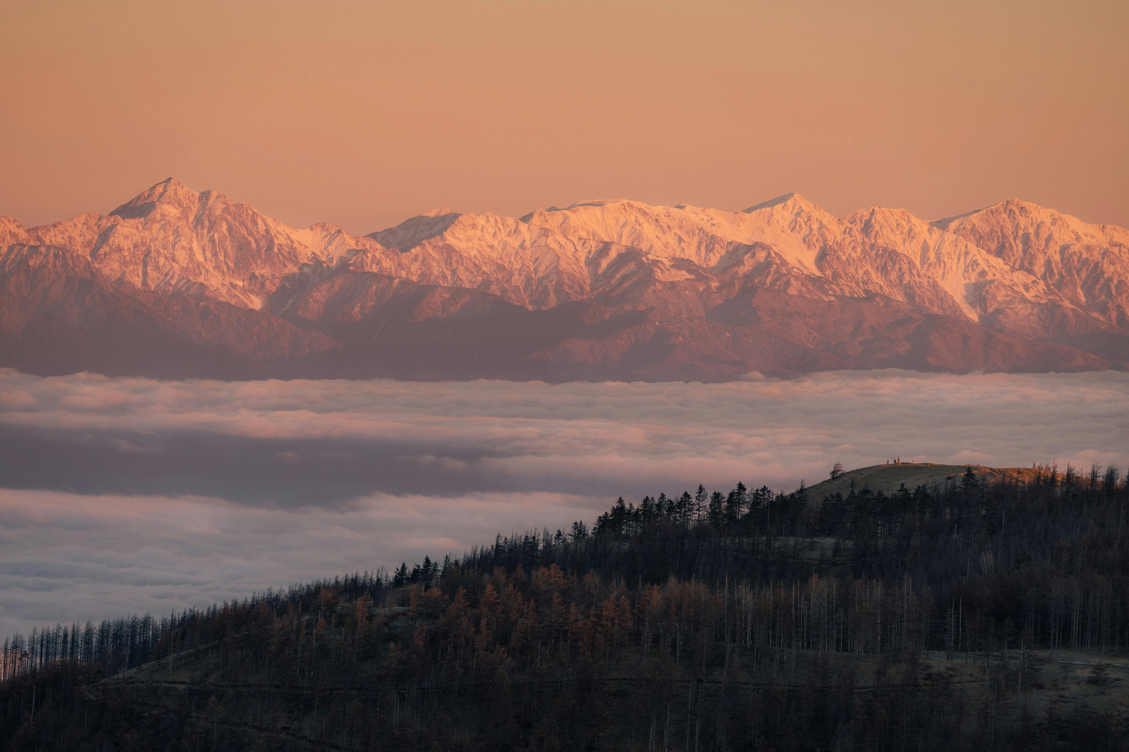 Snow-capped mountains under a colorful sunrise sky