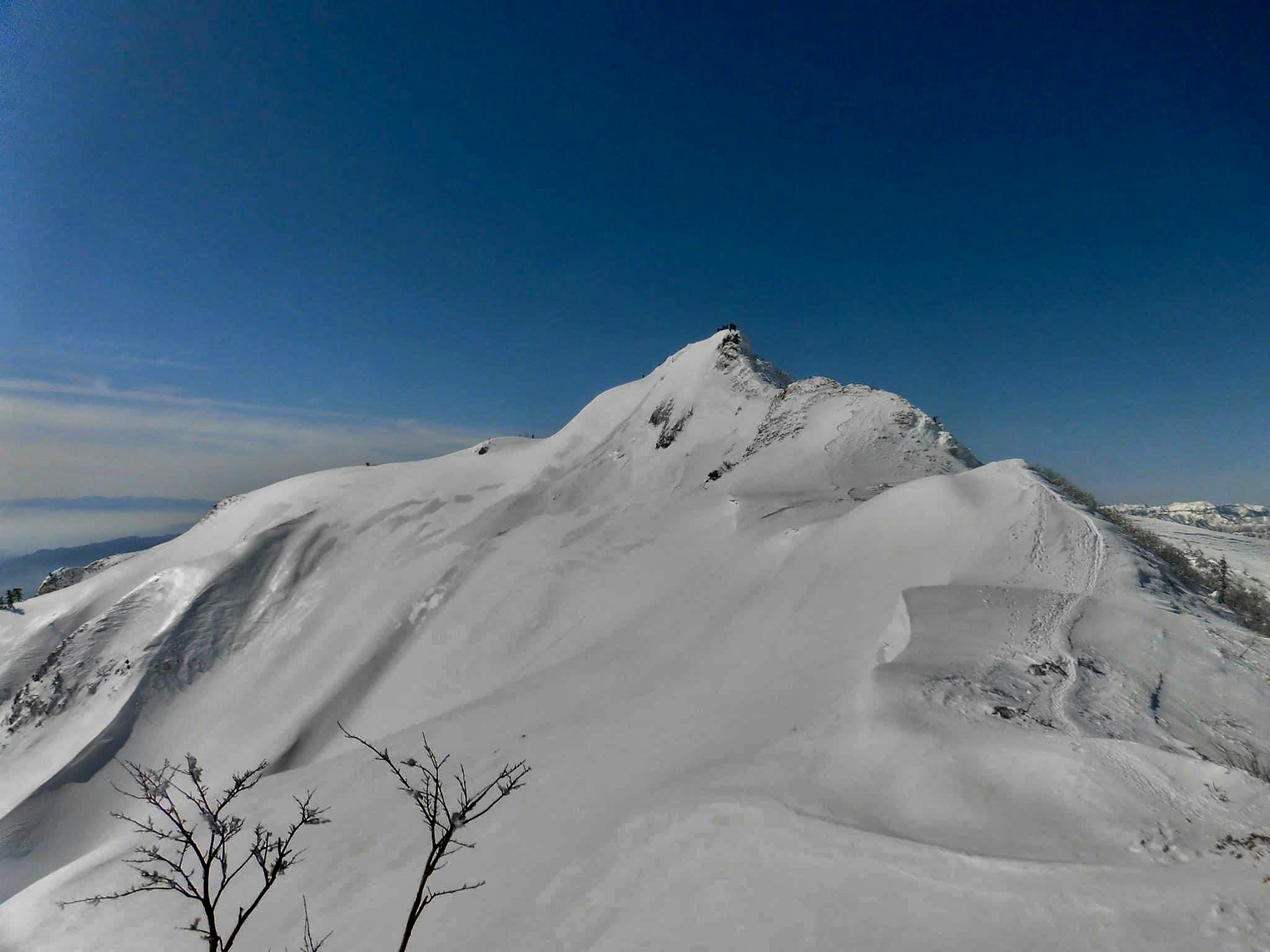 雪覆盖的山峰在晴朗的蓝天下