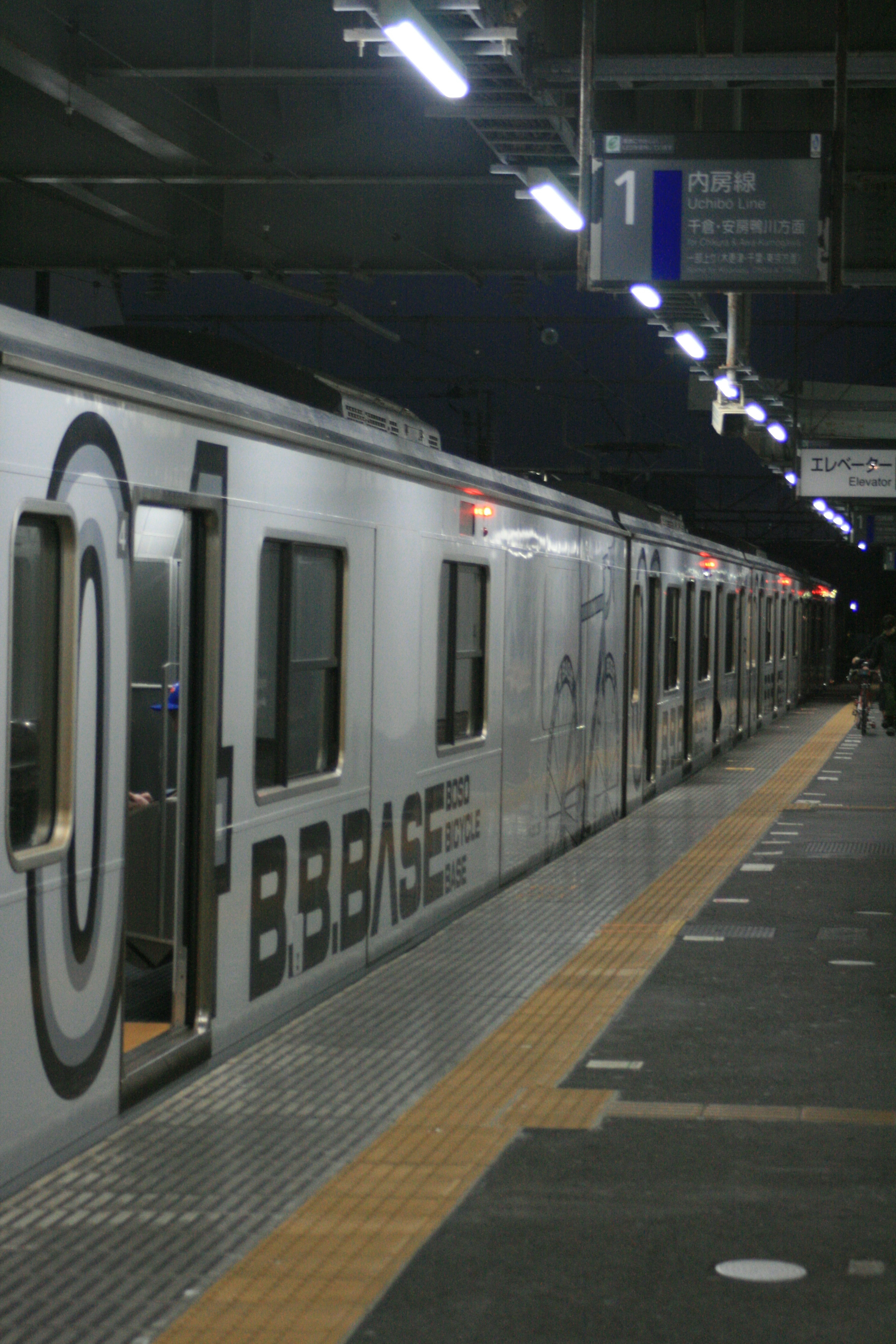 Train blanc arrêté sur un quai de station avec un éclairage lumineux