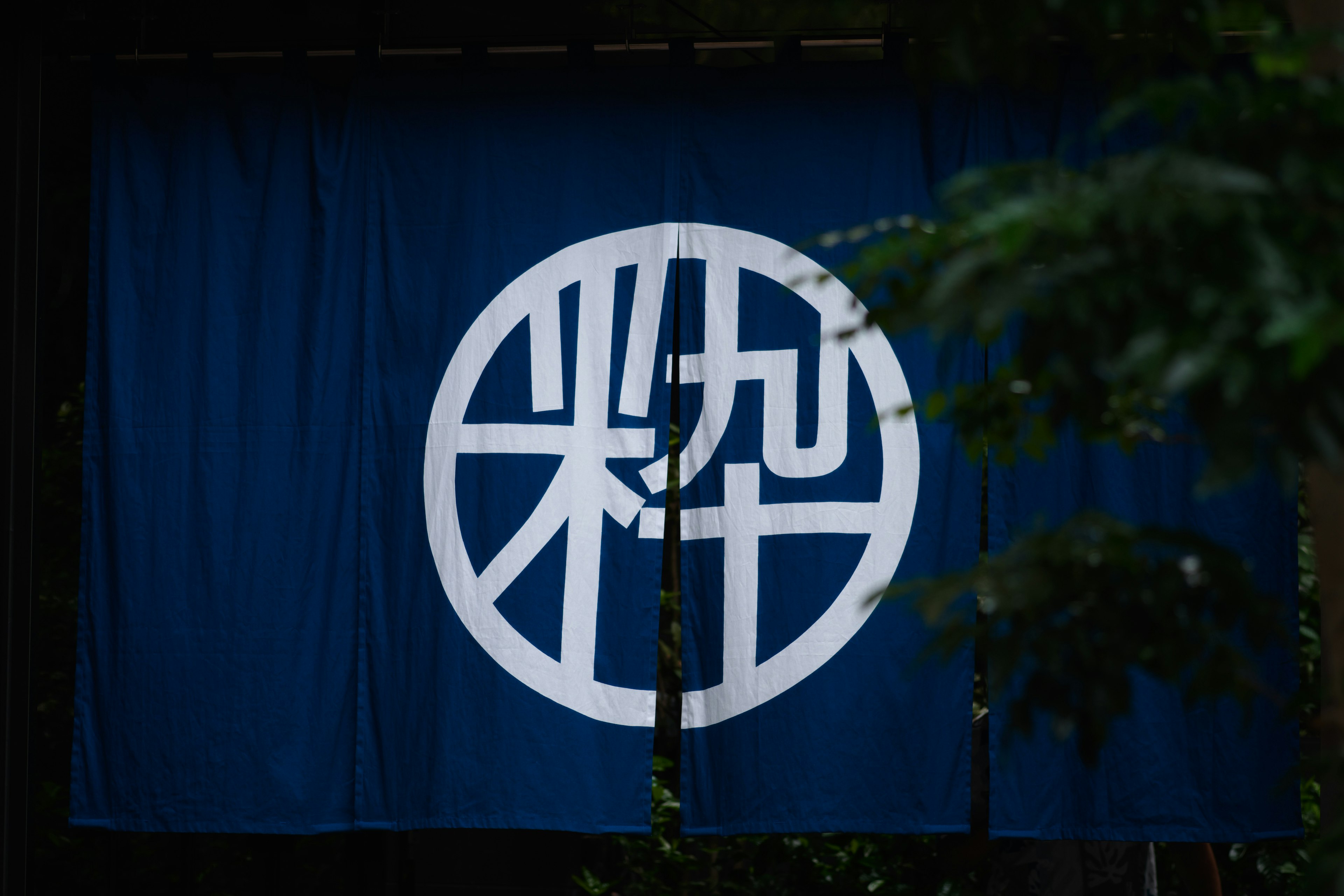 A blue fabric banner featuring a circular white design