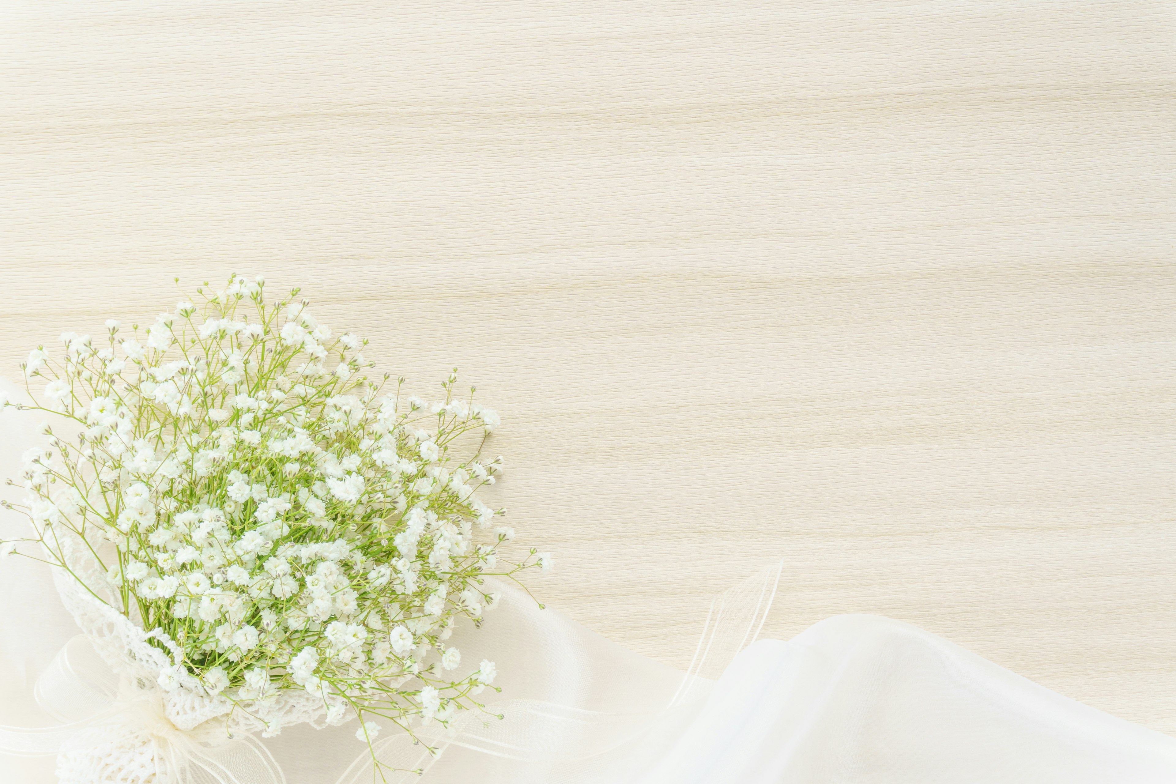 Un pequeño ramo de flores blancas sobre un fondo claro con tela suave