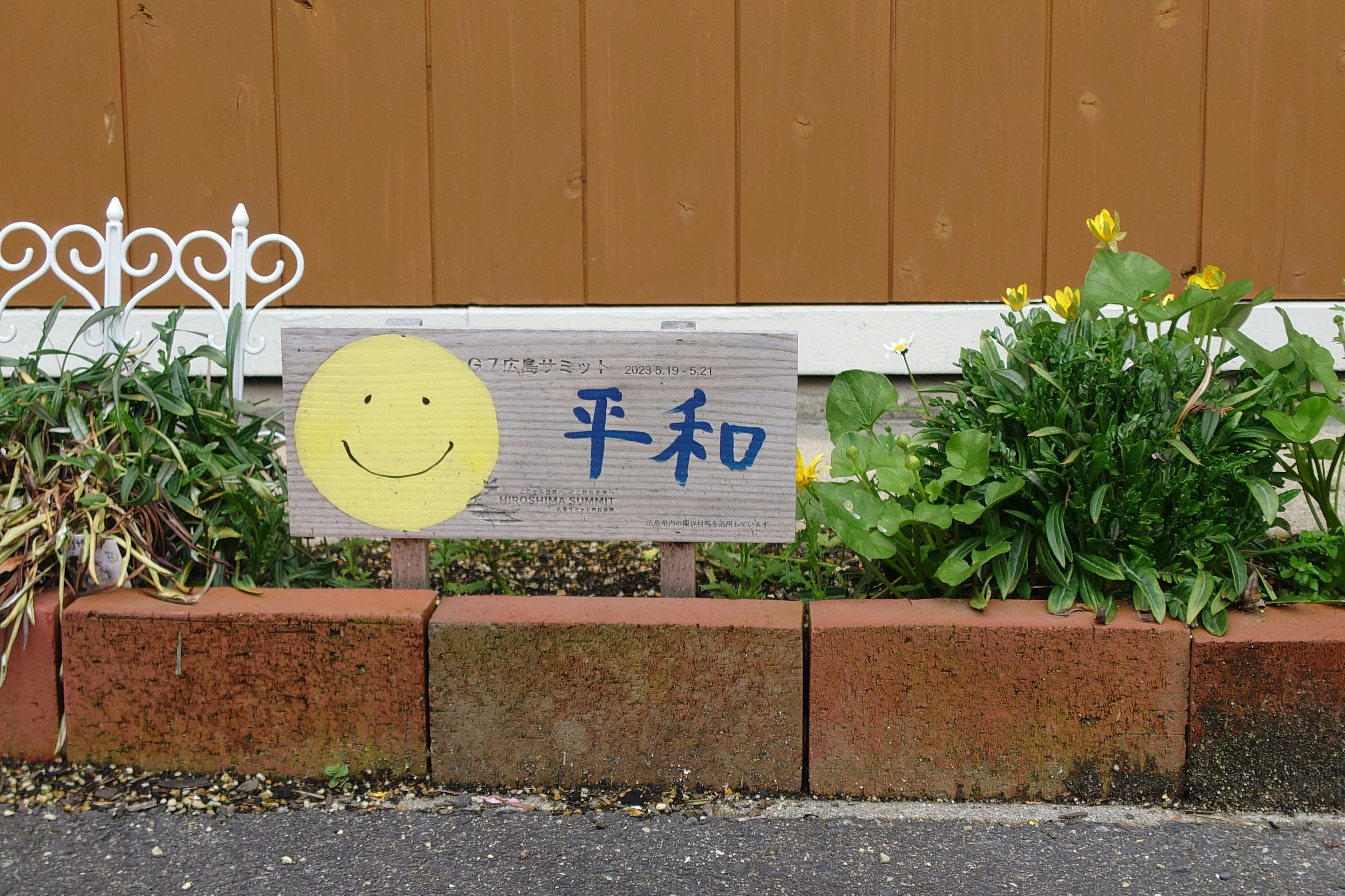 Una scena di giardino con un sorriso e un cartello con la parola pace in blu