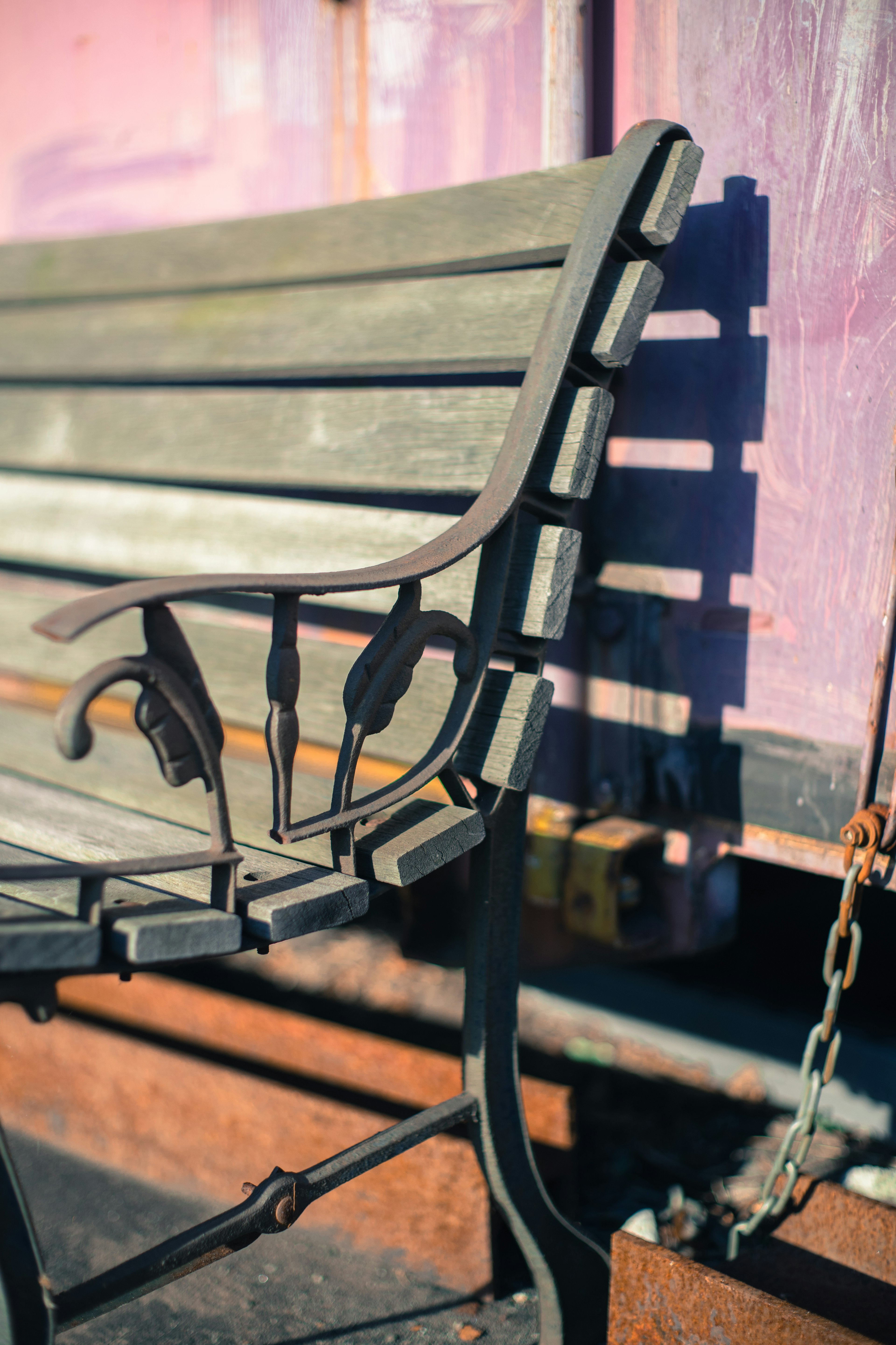 Gros plan d'un vieux banc en métal montrant un design de dossier complexe et des ombres