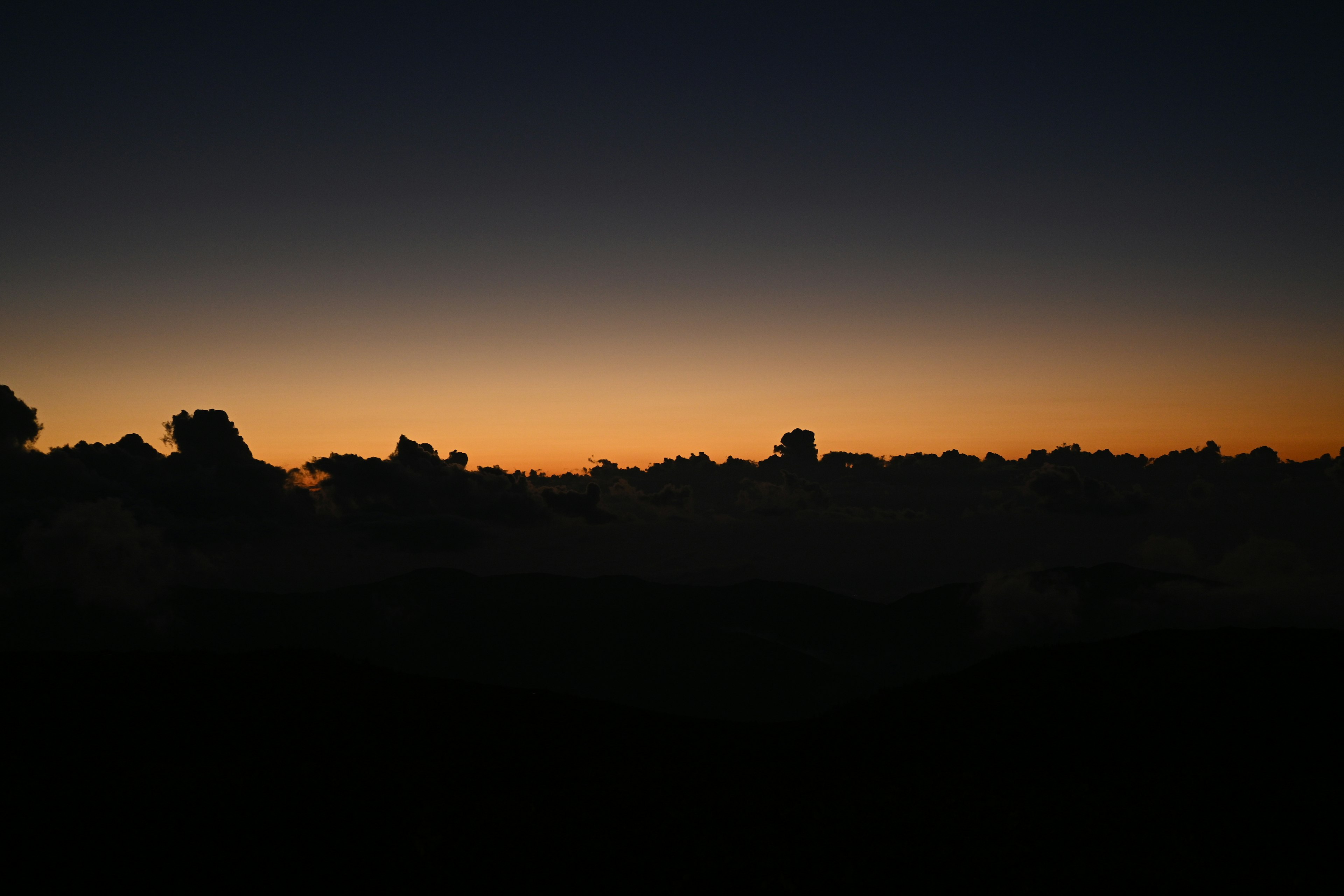 夕暮れ時の雲のシルエットとオレンジ色のグラデーション